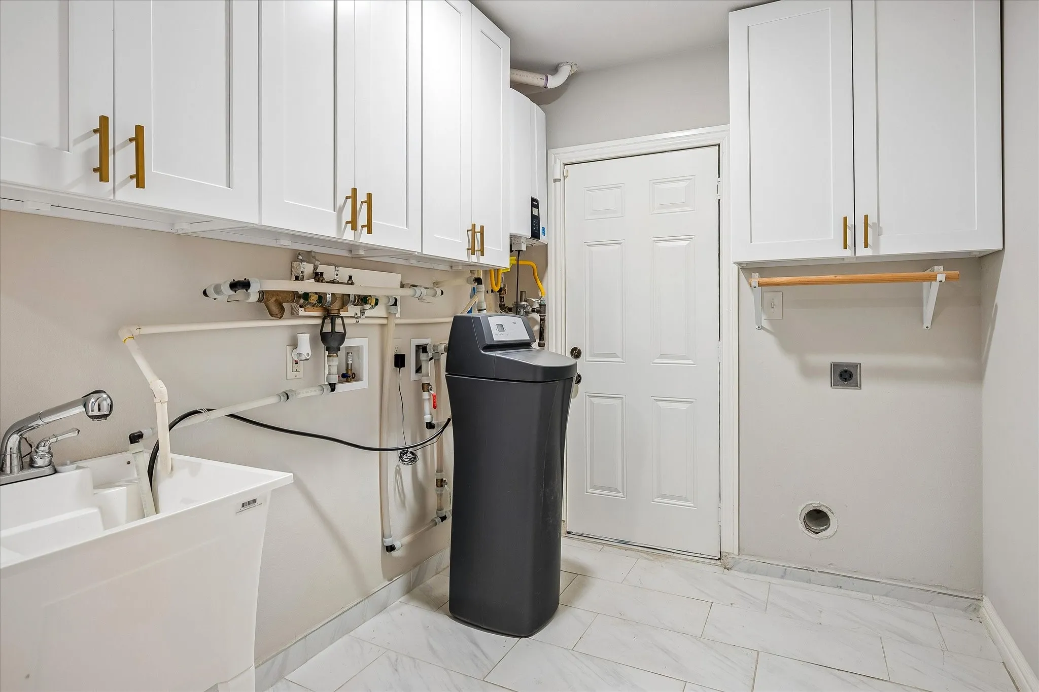 The laundry room has lots of storage, a sink, water softner and tankless water heater. The