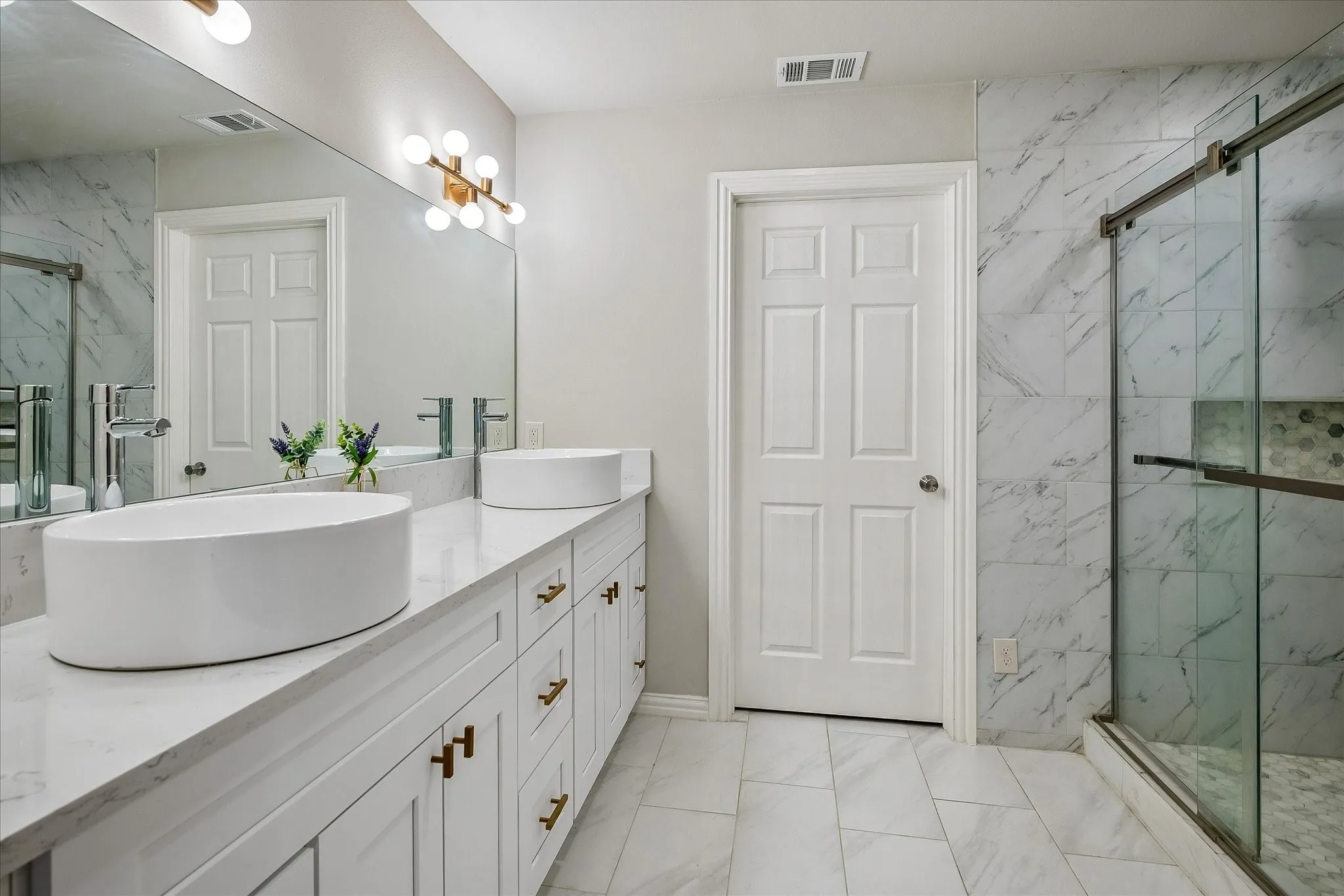 The Primary Bathroom, Ensuite, on the 1st level has been completely remodeled and has heated floors,  dual sinks, an oversized shower and a huge walk-in closet.