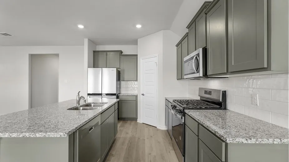 Contemporary kitchen featuring a spacious island with an undermount sink, granite countertops, and gray shaker-style cabinetry