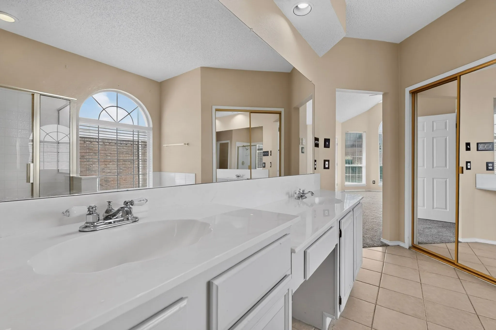 Double vanity with white countertops, integrated sinks, and chrome fixtures