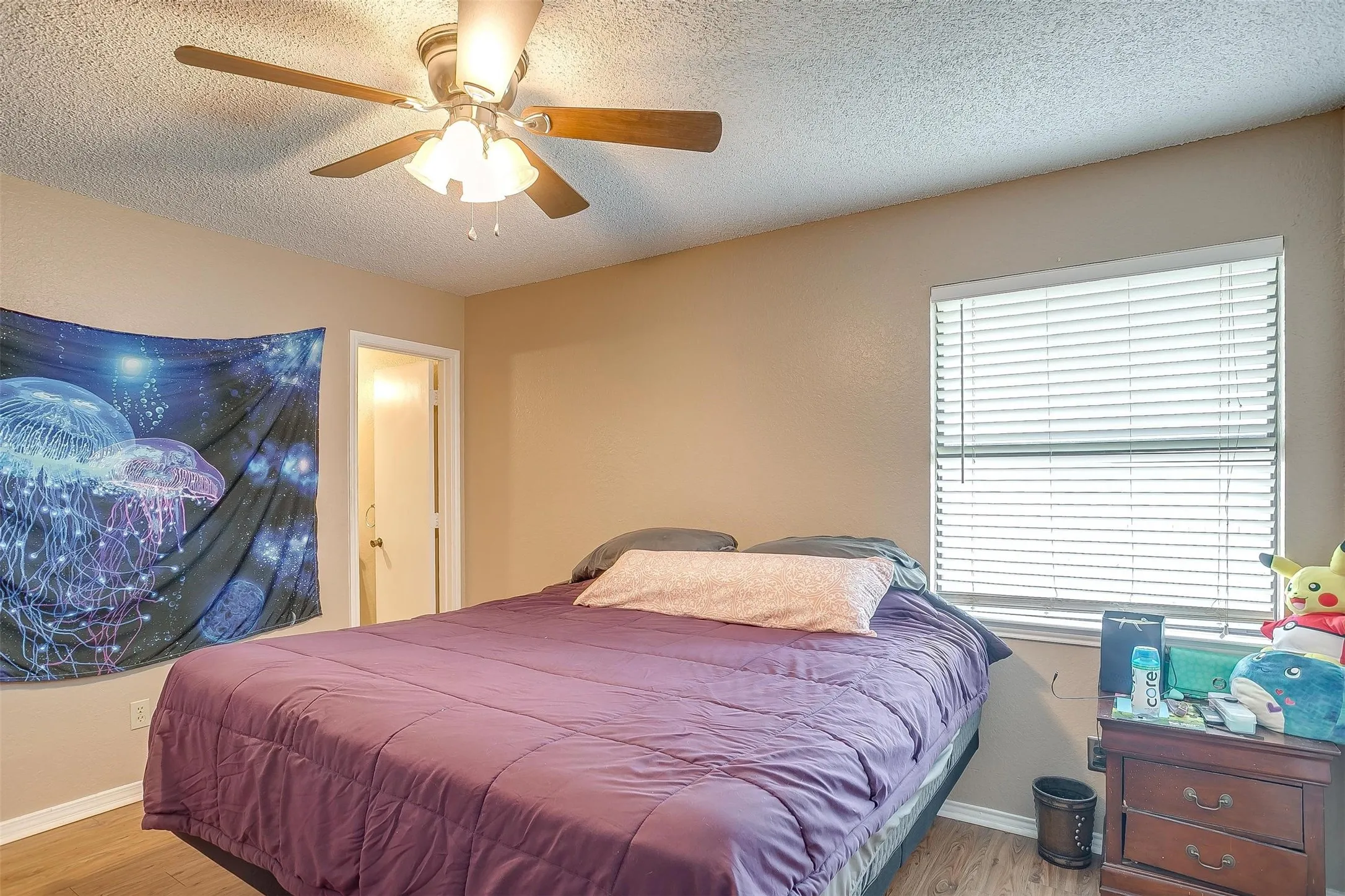 Bedroom featuring warm neutral color scheme and a center-mounted ceiling fan with integrated lights.