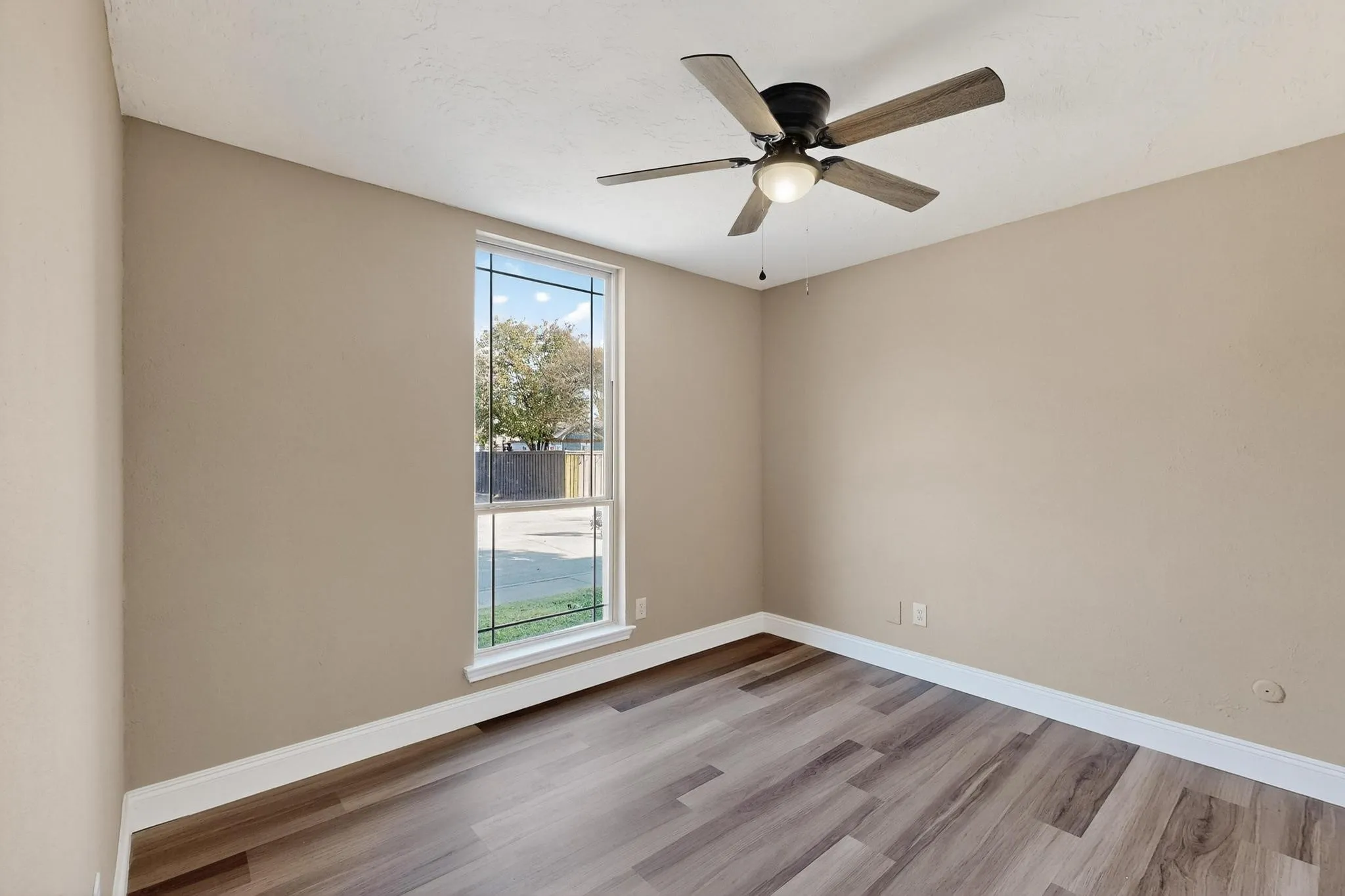 Unfurnished room featuring light wood-style flooring and a ceiling fan