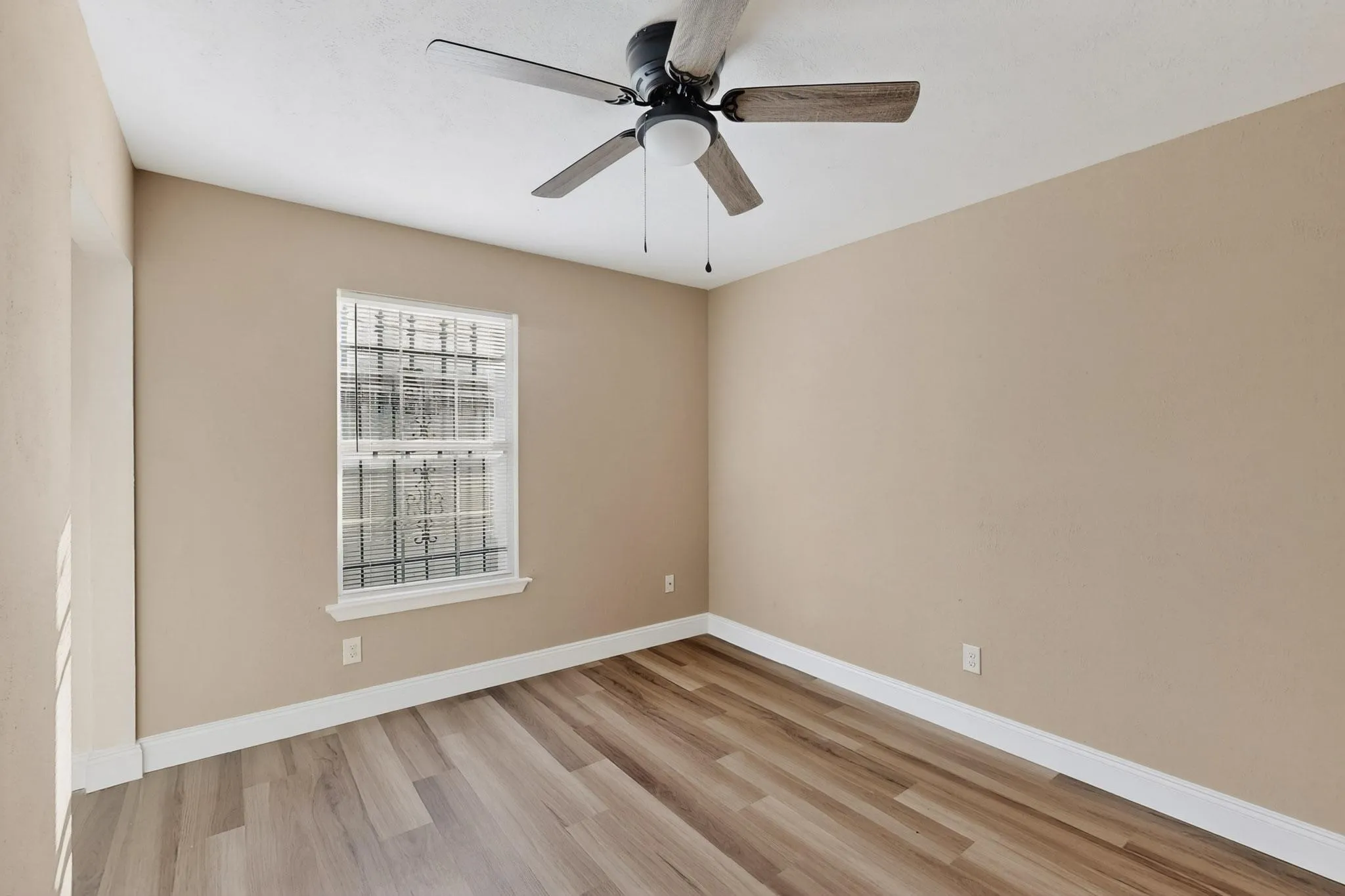 Unfurnished room featuring light wood-style flooring and a ceiling fan