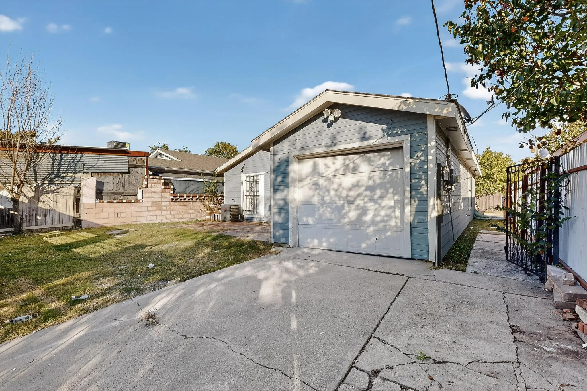 View of home's exterior with driveway, a garage, and an outbuilding