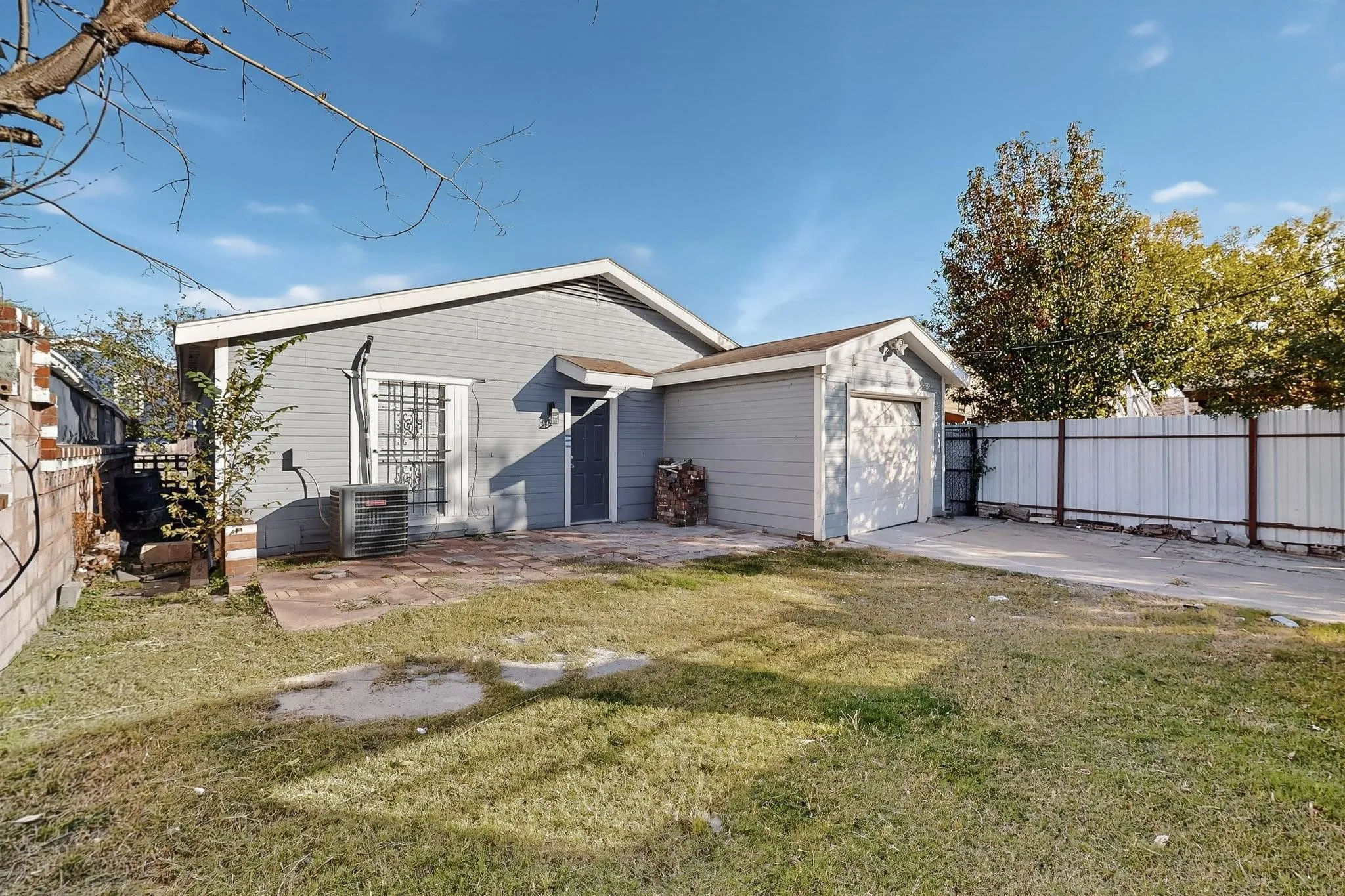 Rear view of property featuring a patio area, driveway, and an attached garage