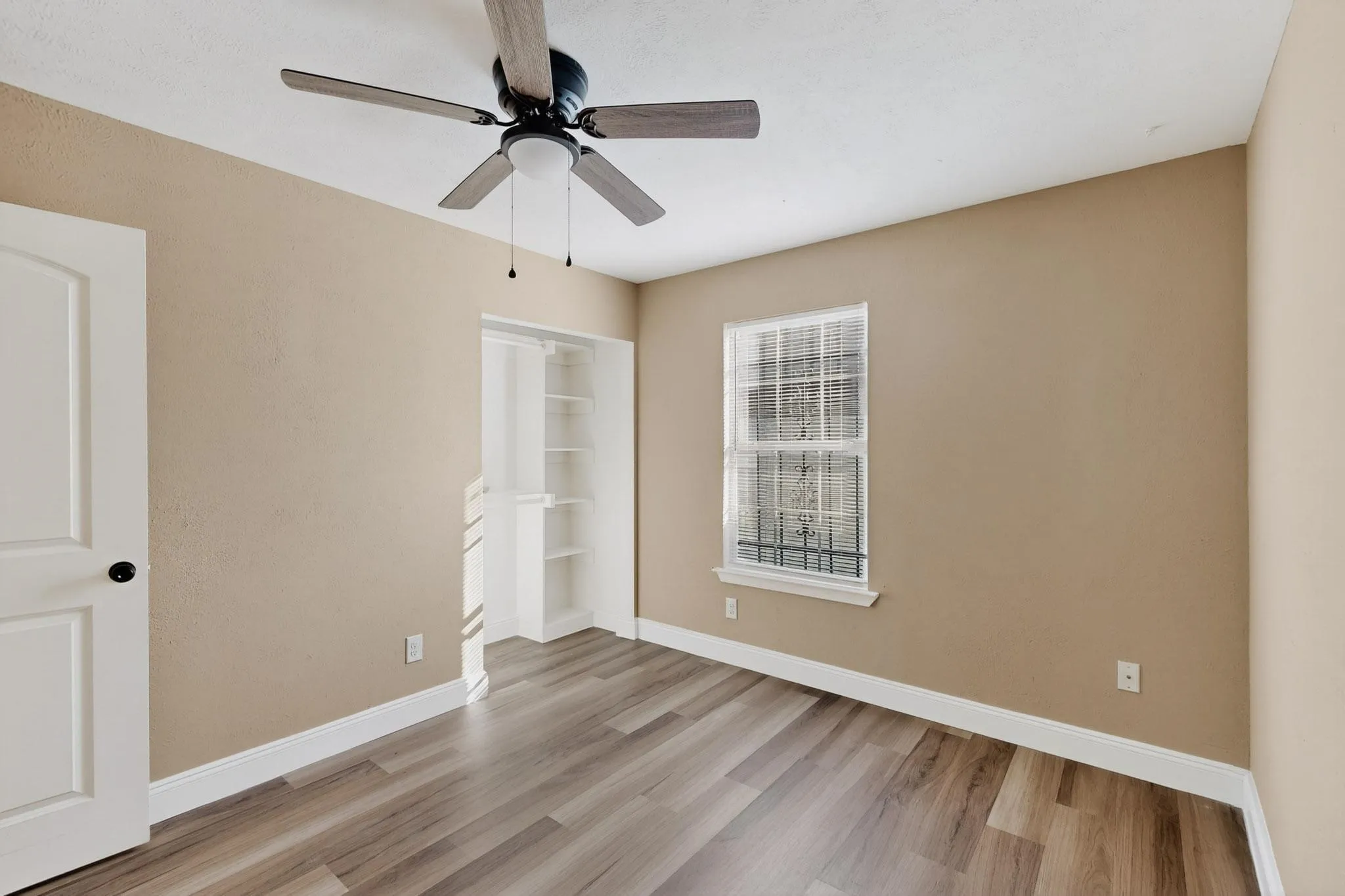Unfurnished bedroom featuring light wood-style floors, a ceiling fan, and a closet