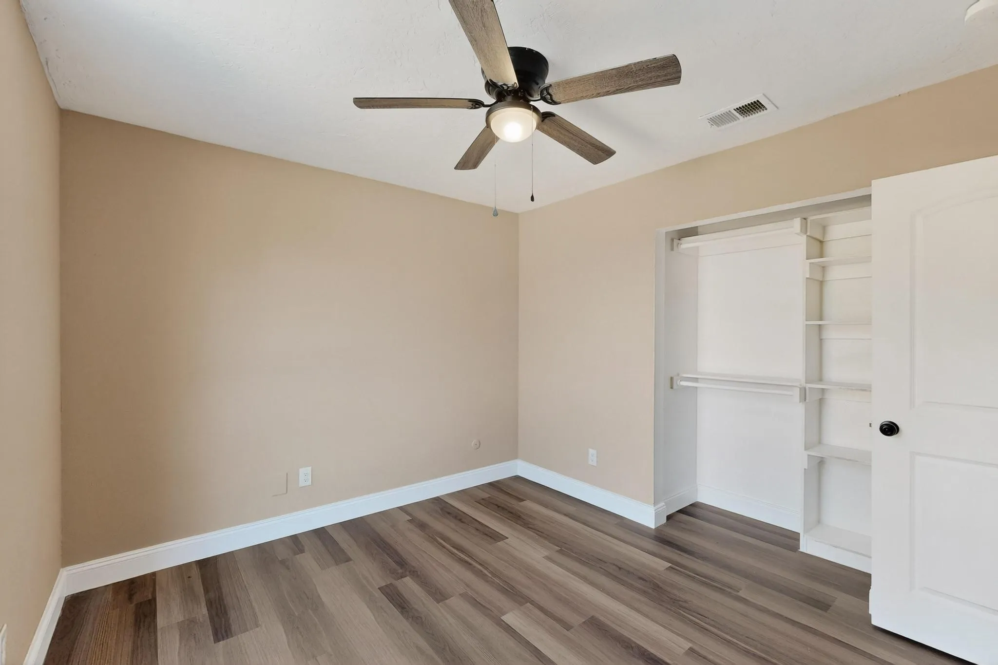 Unfurnished bedroom featuring light wood-type flooring, a closet, and ceiling fan