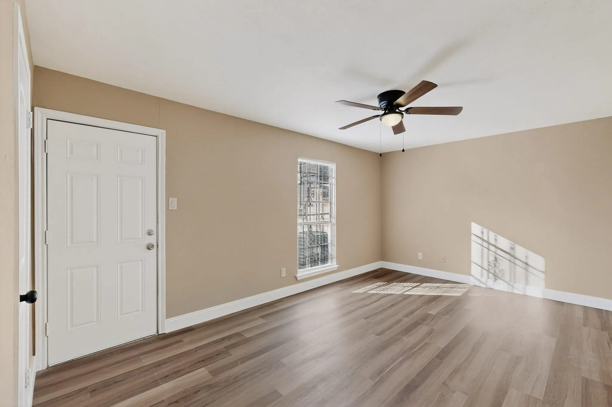 Spare room with wood finished floors and a ceiling fan