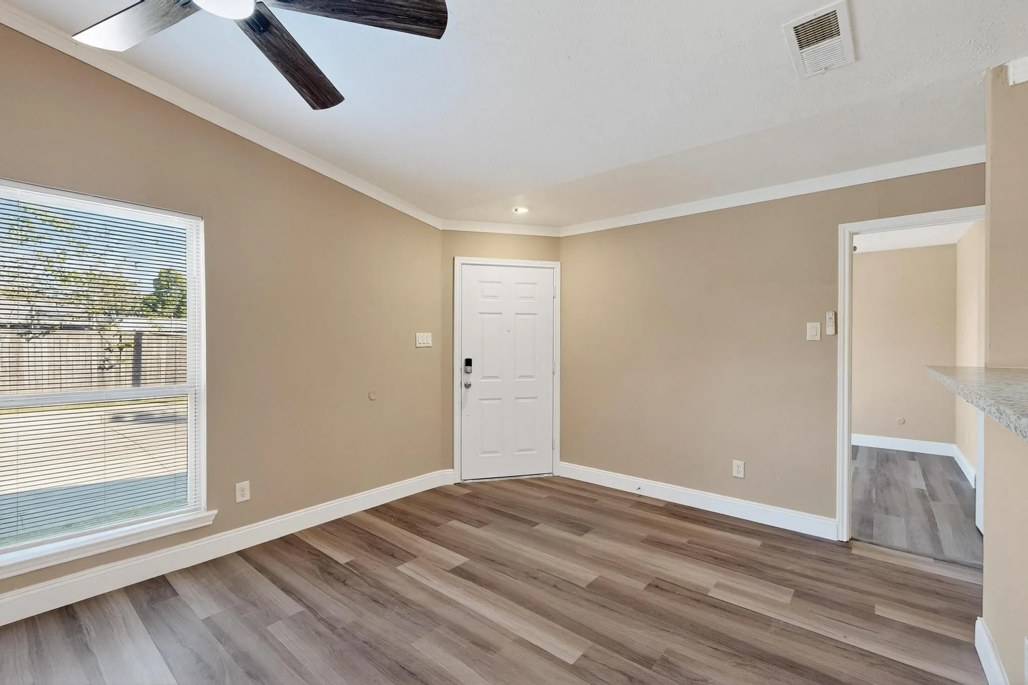Empty room featuring crown molding, light wood-type flooring, a ceiling fan, and recessed lighting