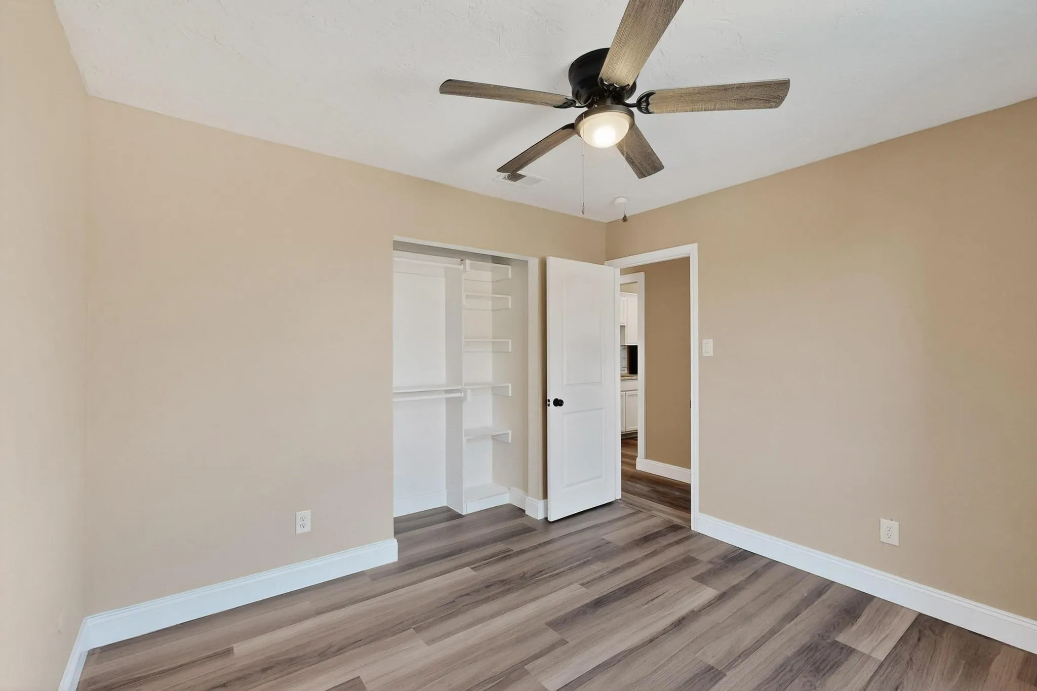 Unfurnished bedroom featuring light wood-style flooring, a ceiling fan, and a closet