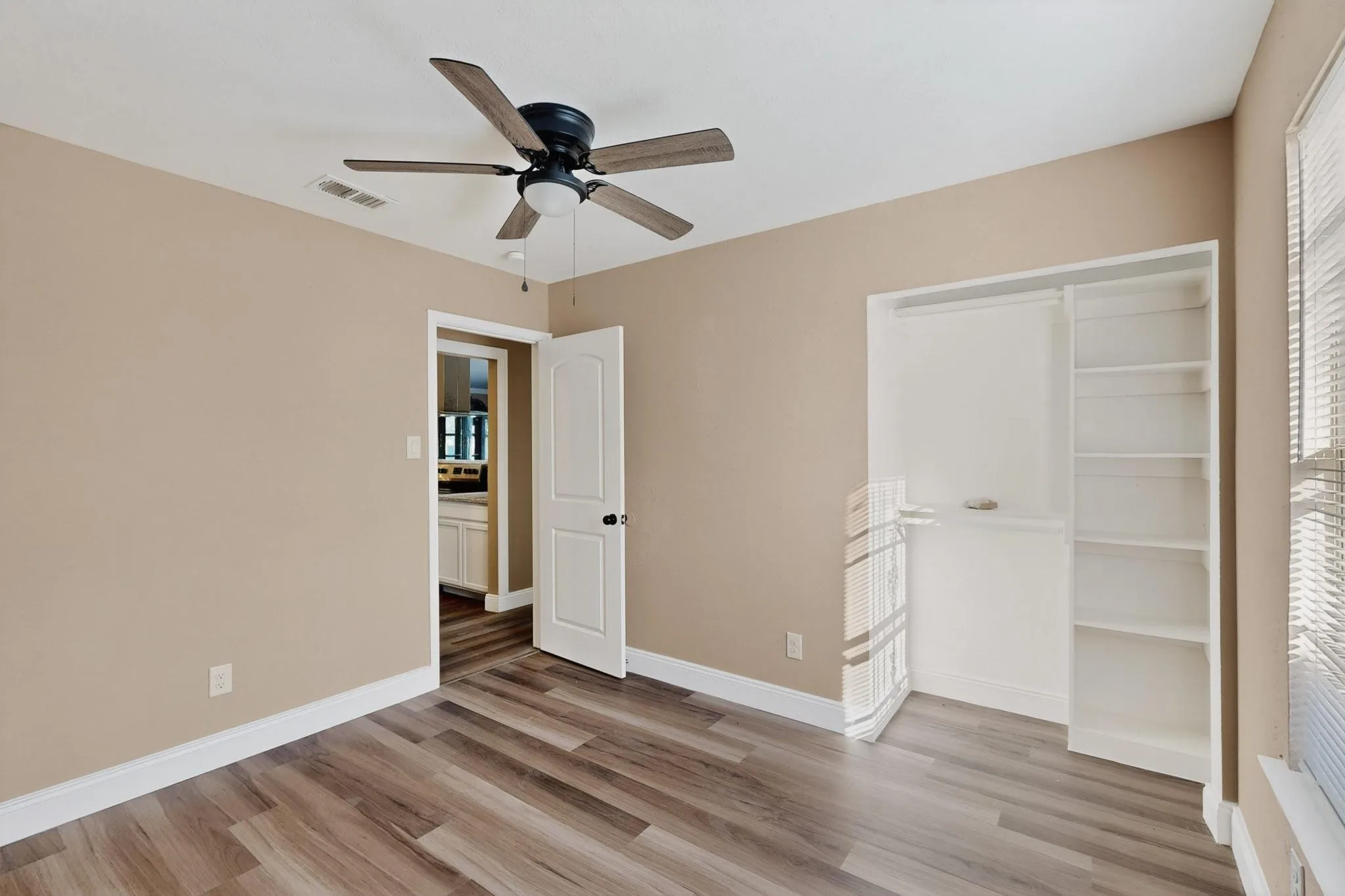 Unfurnished bedroom featuring light wood finished floors, ceiling fan, and a closet