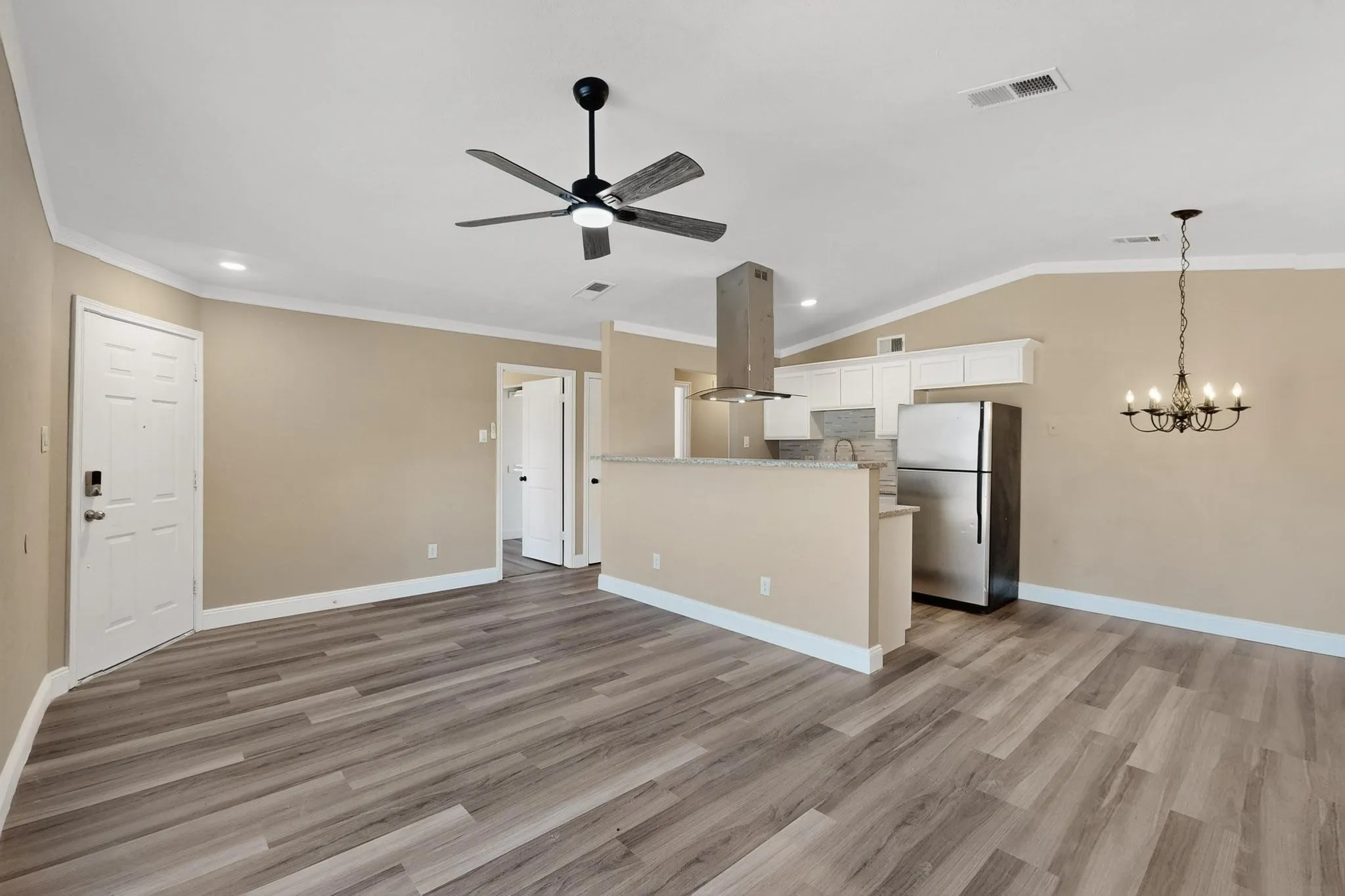 Unfurnished living room featuring ornamental molding, light wood-style floors, a ceiling fan, recessed lighting, and lofted ceiling