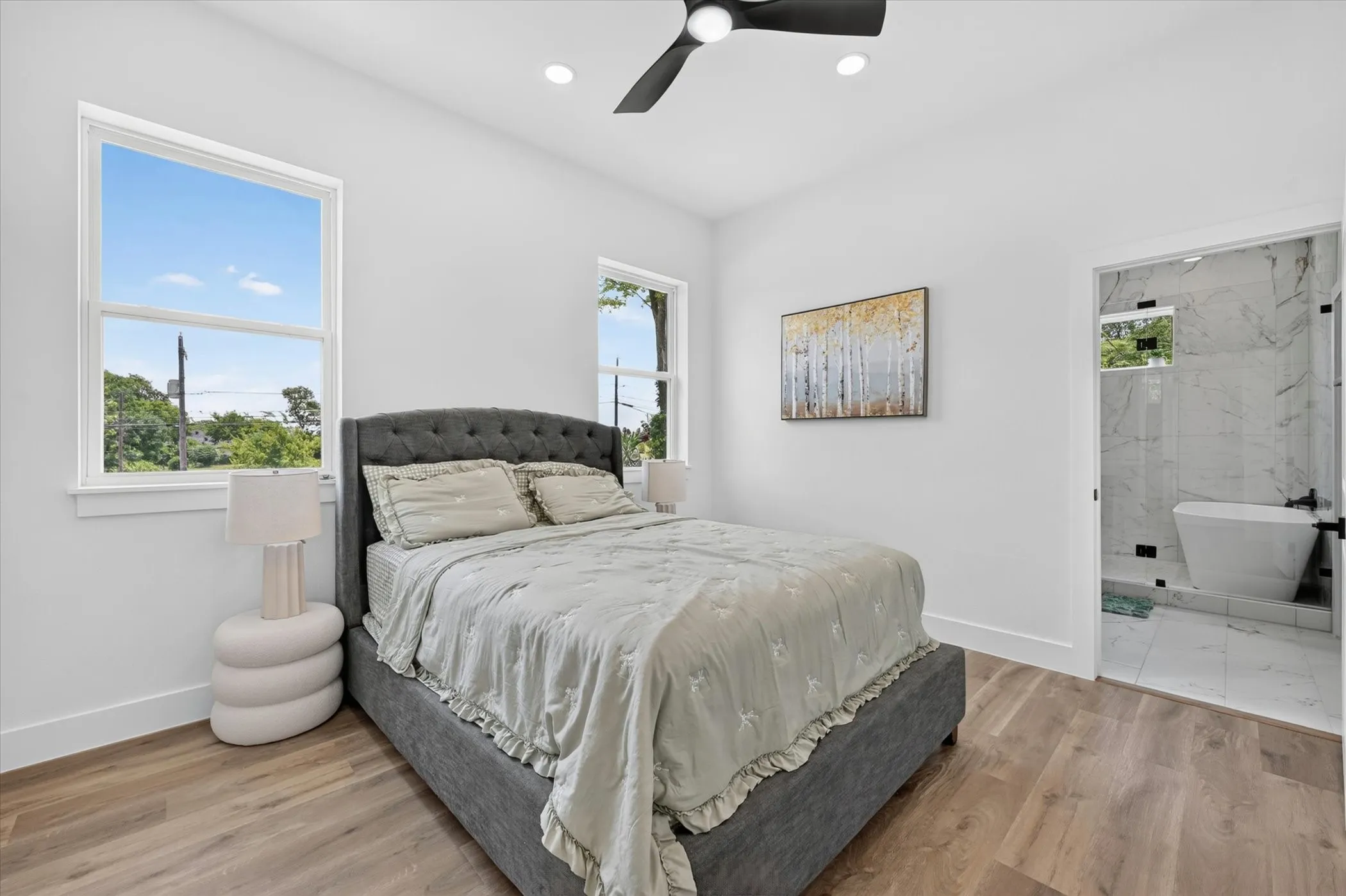 Spacious room featuring wood-finish flooring and two bright windows