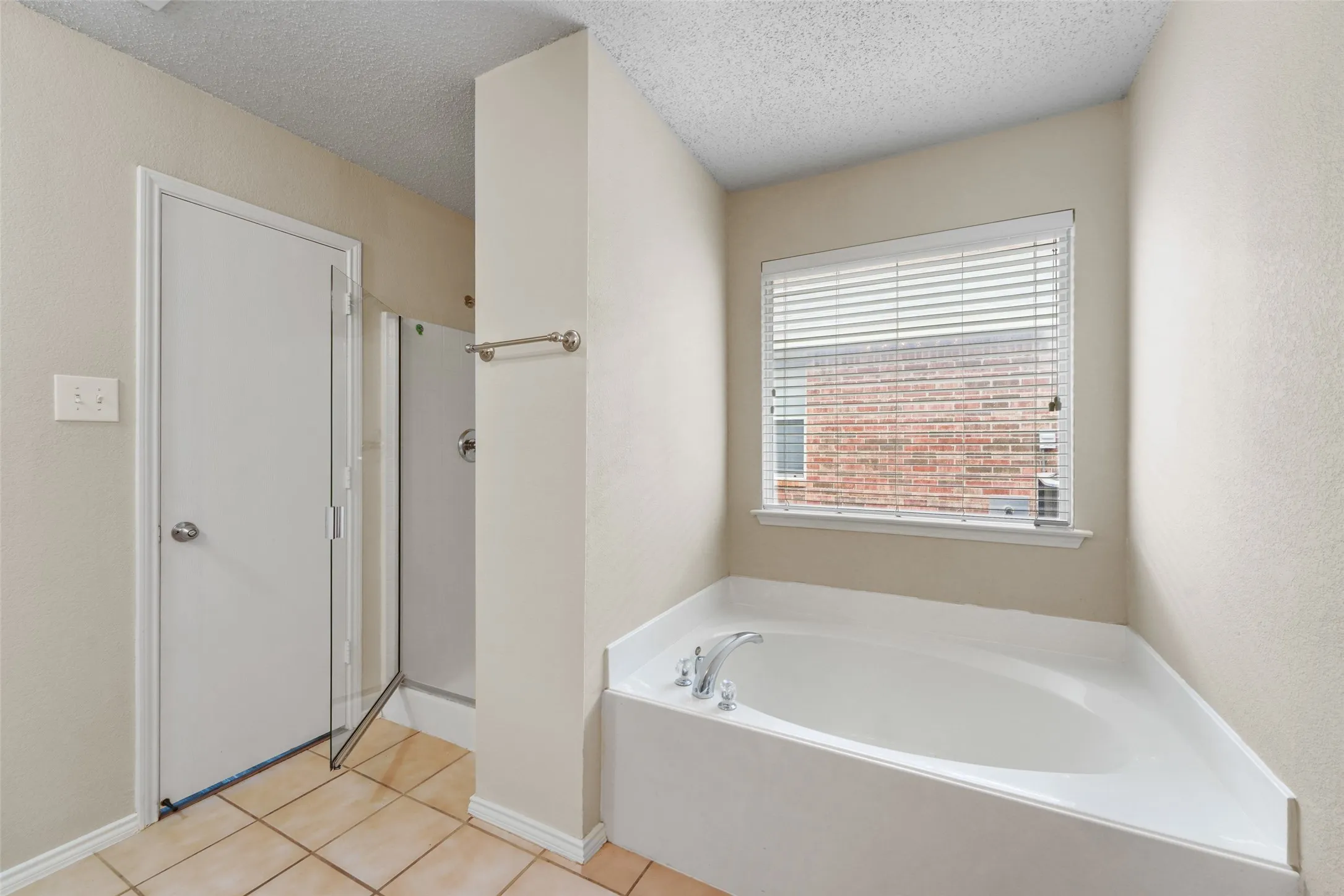 Corner soaking tub with a window featuring horizontal blinds