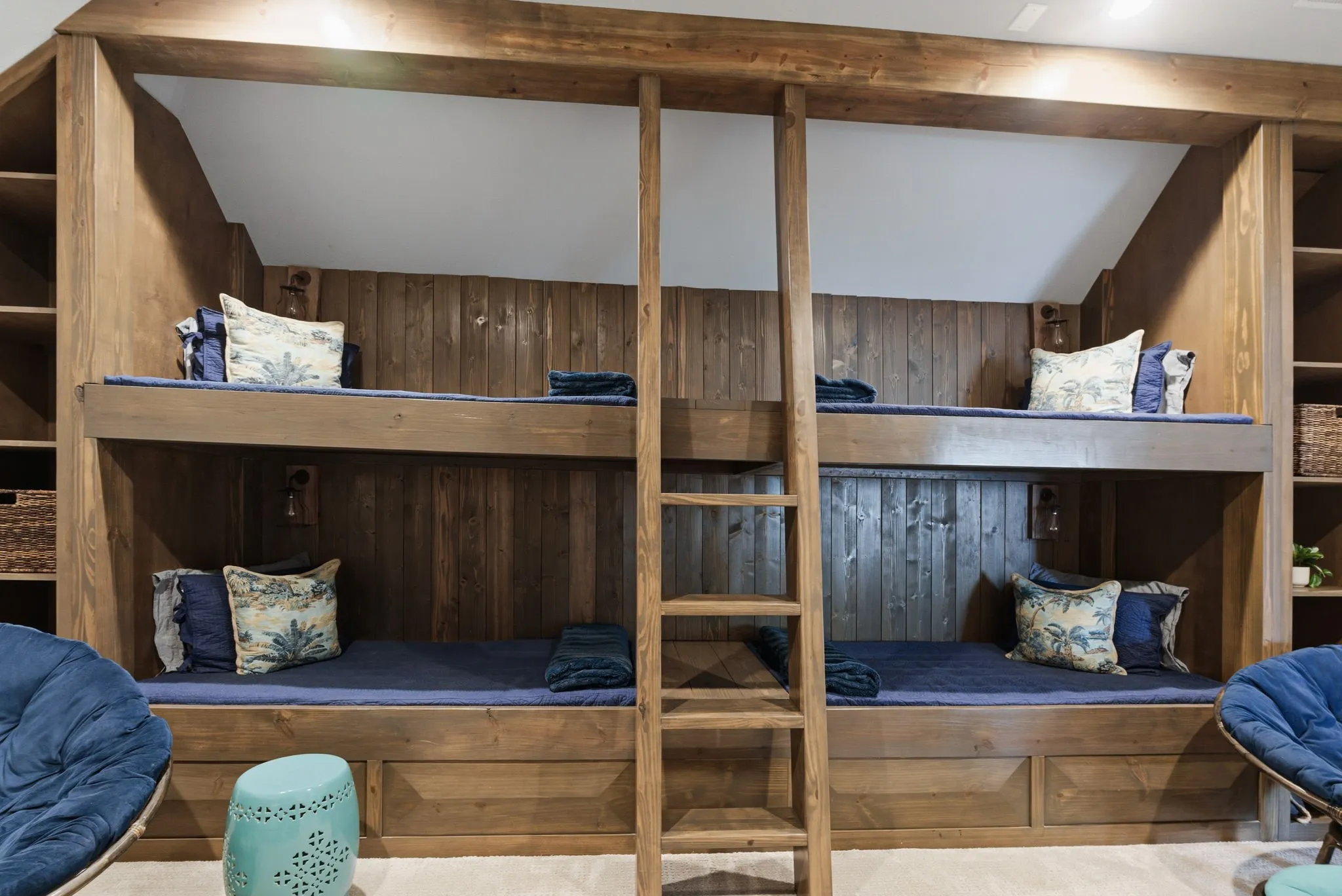 Built-in bunk beds with wood-paneled walls, integrated shelving, and recessed lighting