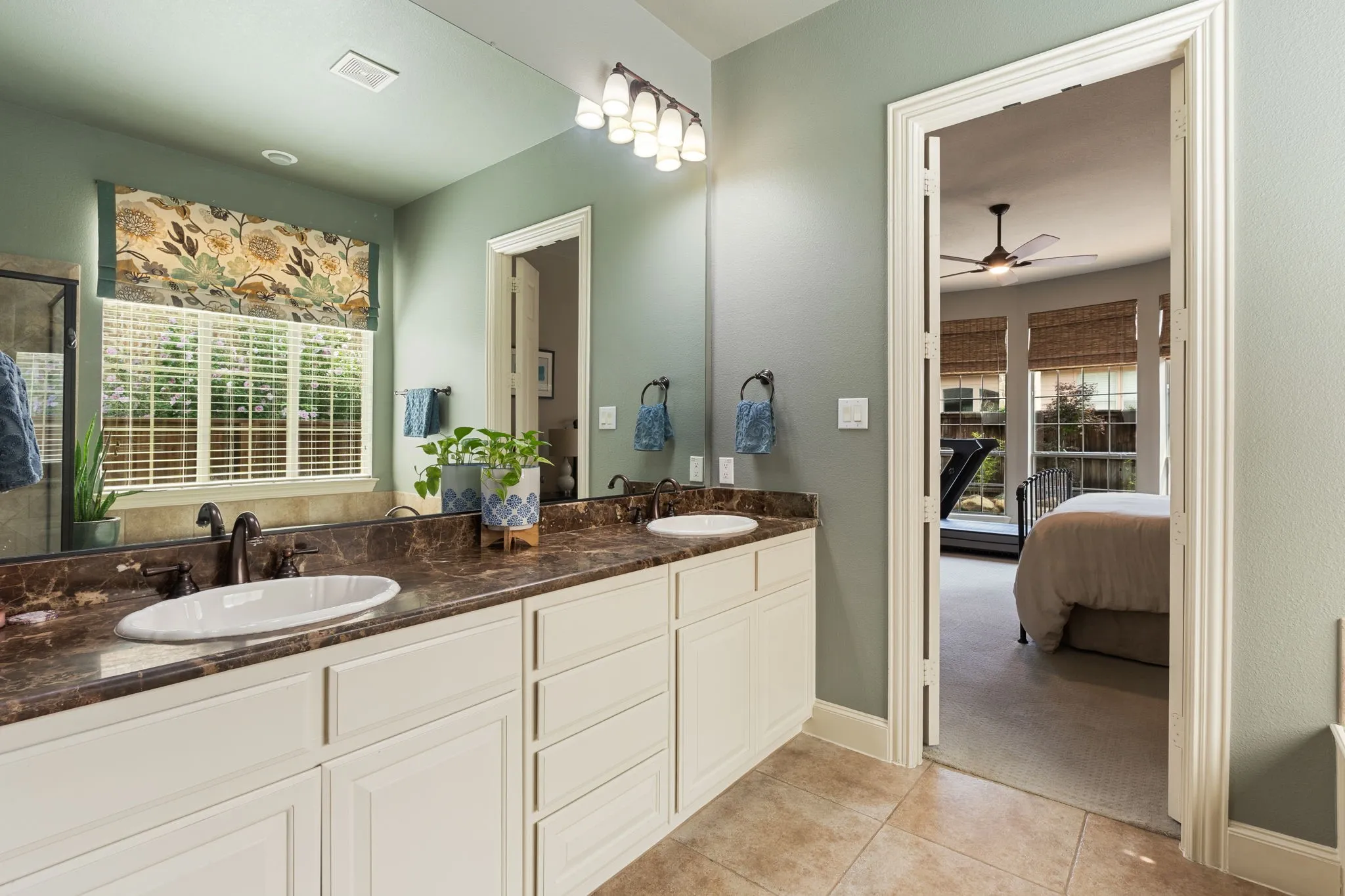 Bathroom vanity featuring dual undermount sinks, bronze-finish fixtures, and a spacious countertop