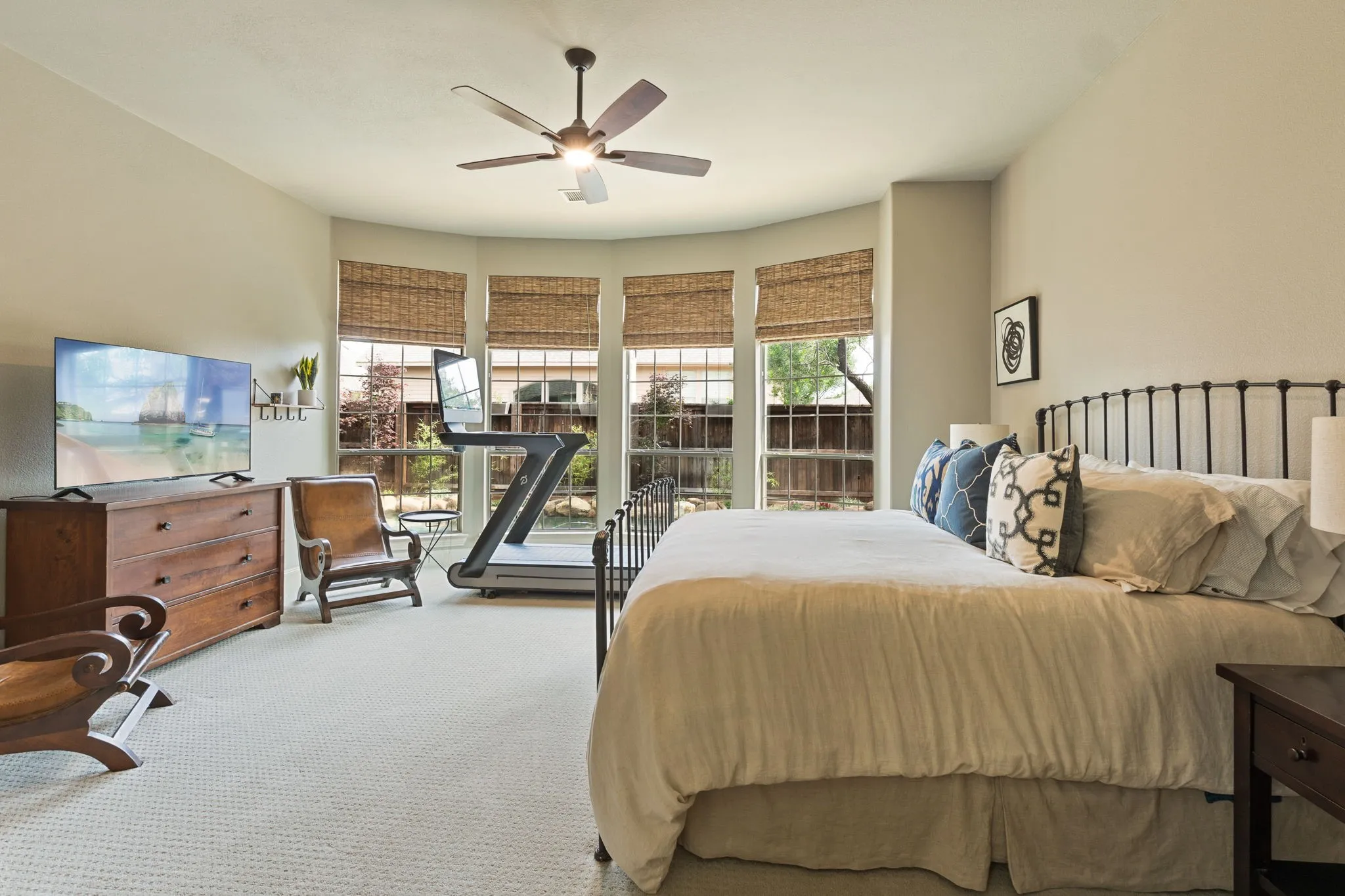 Bedroom featuring a bay window with natural light, textured window treatments, and carpet flooring