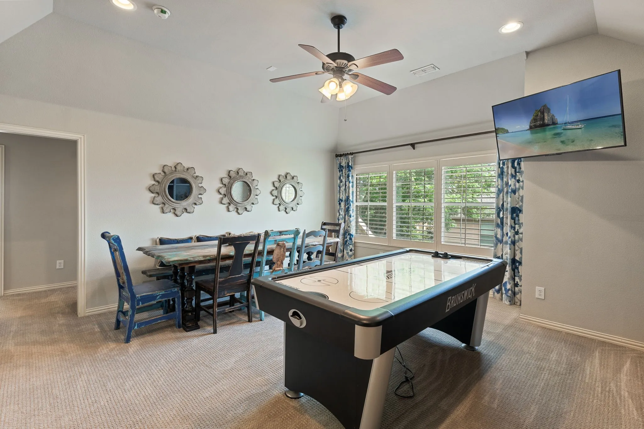 Vaulted ceiling with a ceiling fan, recessed lighting, carpet flooring, and window shutters