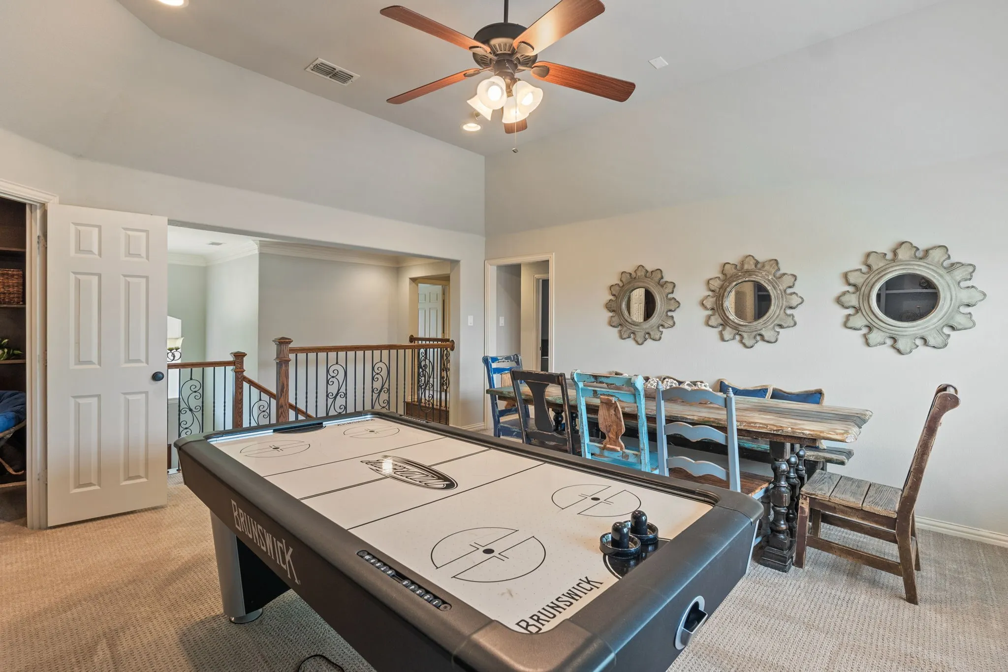 Carpeted bonus room featuring a vaulted ceiling with a ceiling fan, recessed lighting, and a decorative railing overlooking the lower level