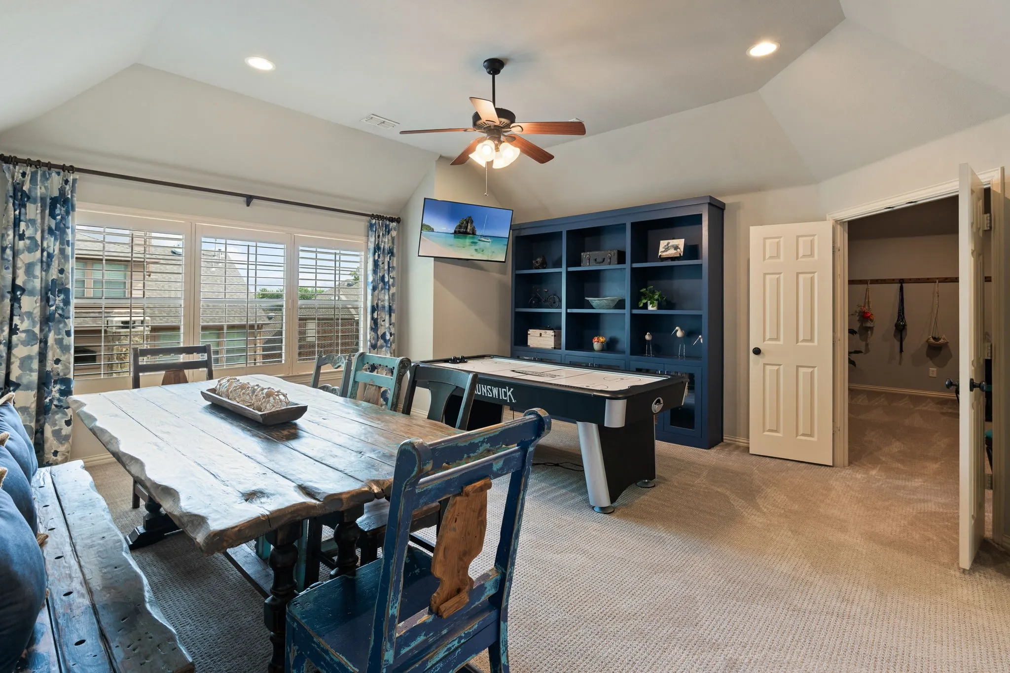 Spacious room featuring vaulted ceilings, a ceiling fan, and recessed lighting