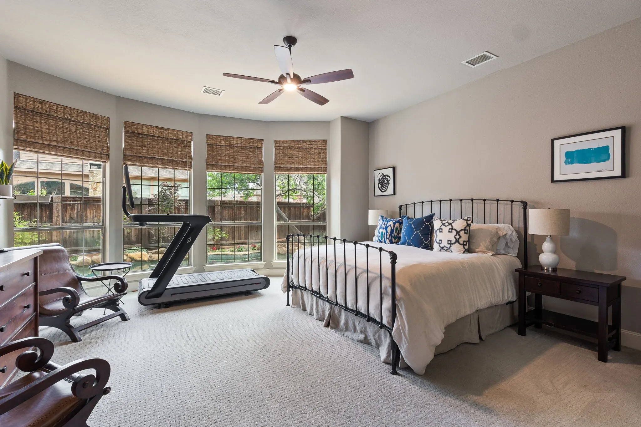 Bay window with woven shades, ceiling fan with integrated lighting, recessed lighting, and carpeted flooring