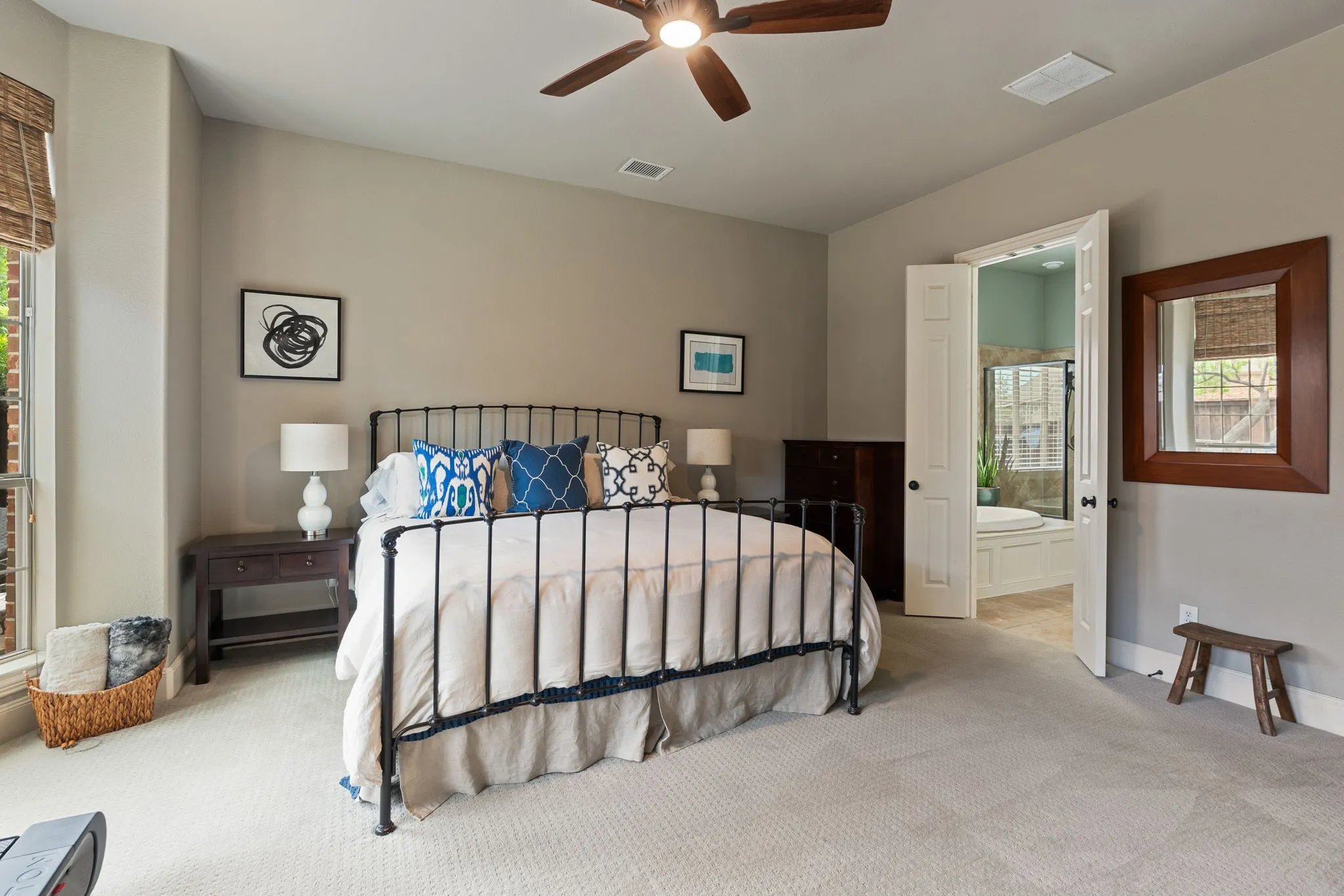 Spacious bedroom featuring neutral wall tones, light-toned carpeting, and a ceiling fan with integrated lighting