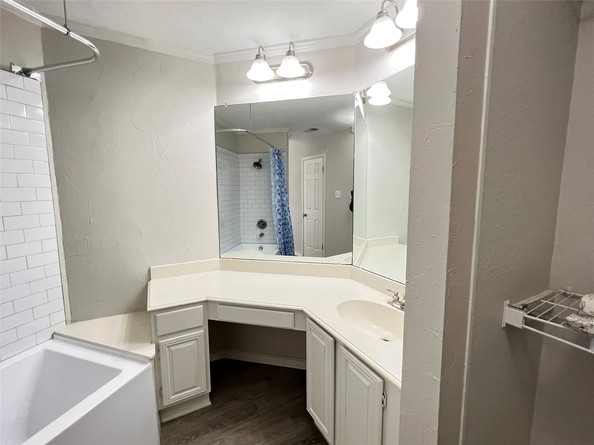 Bathroom featuring a vanity with an integrated sink, built-in storage, and a large wall-mounted mirror