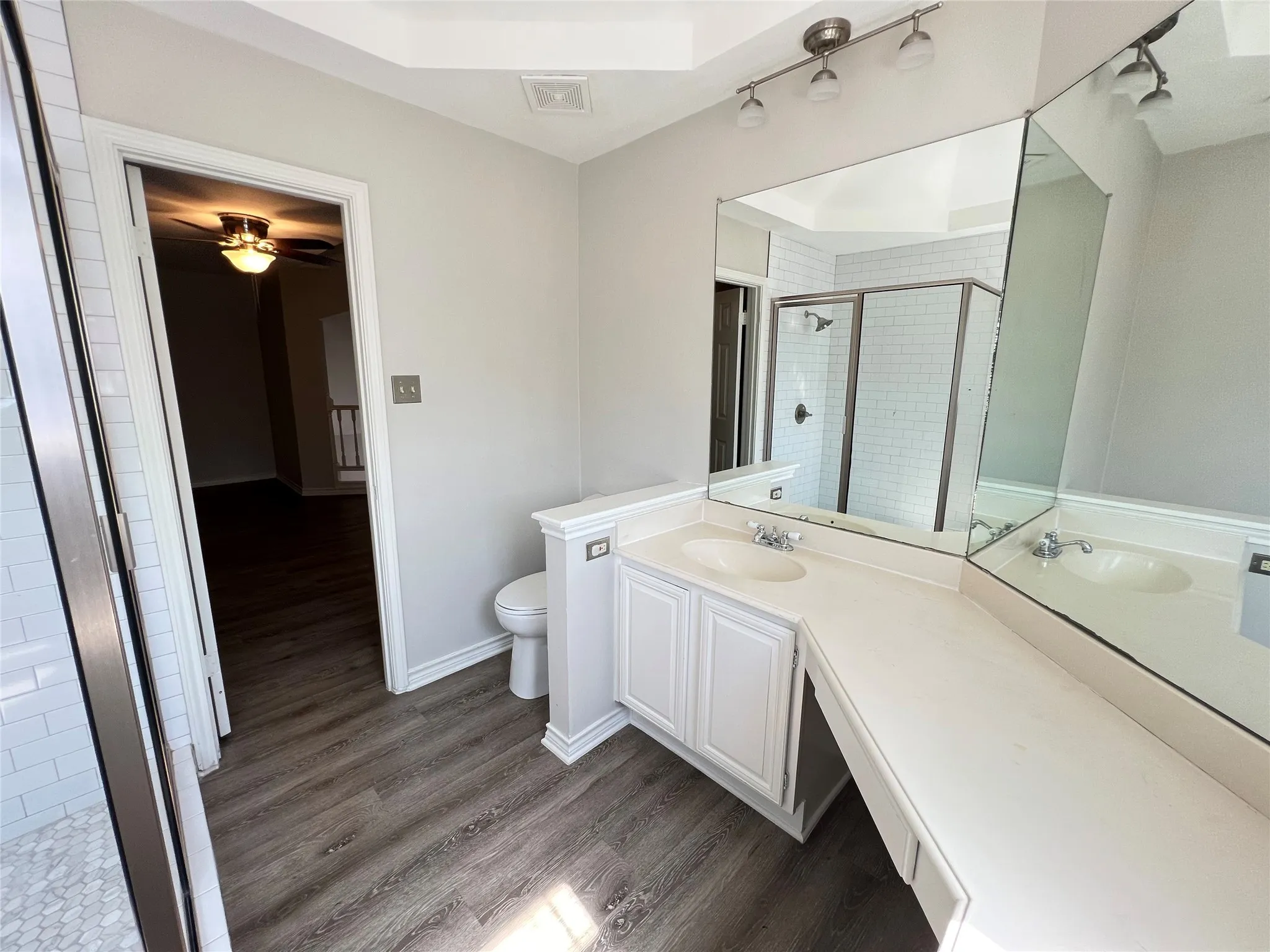 Bathroom featuring a dual vanity with integrated sinks, white cabinetry, and extensive countertop space