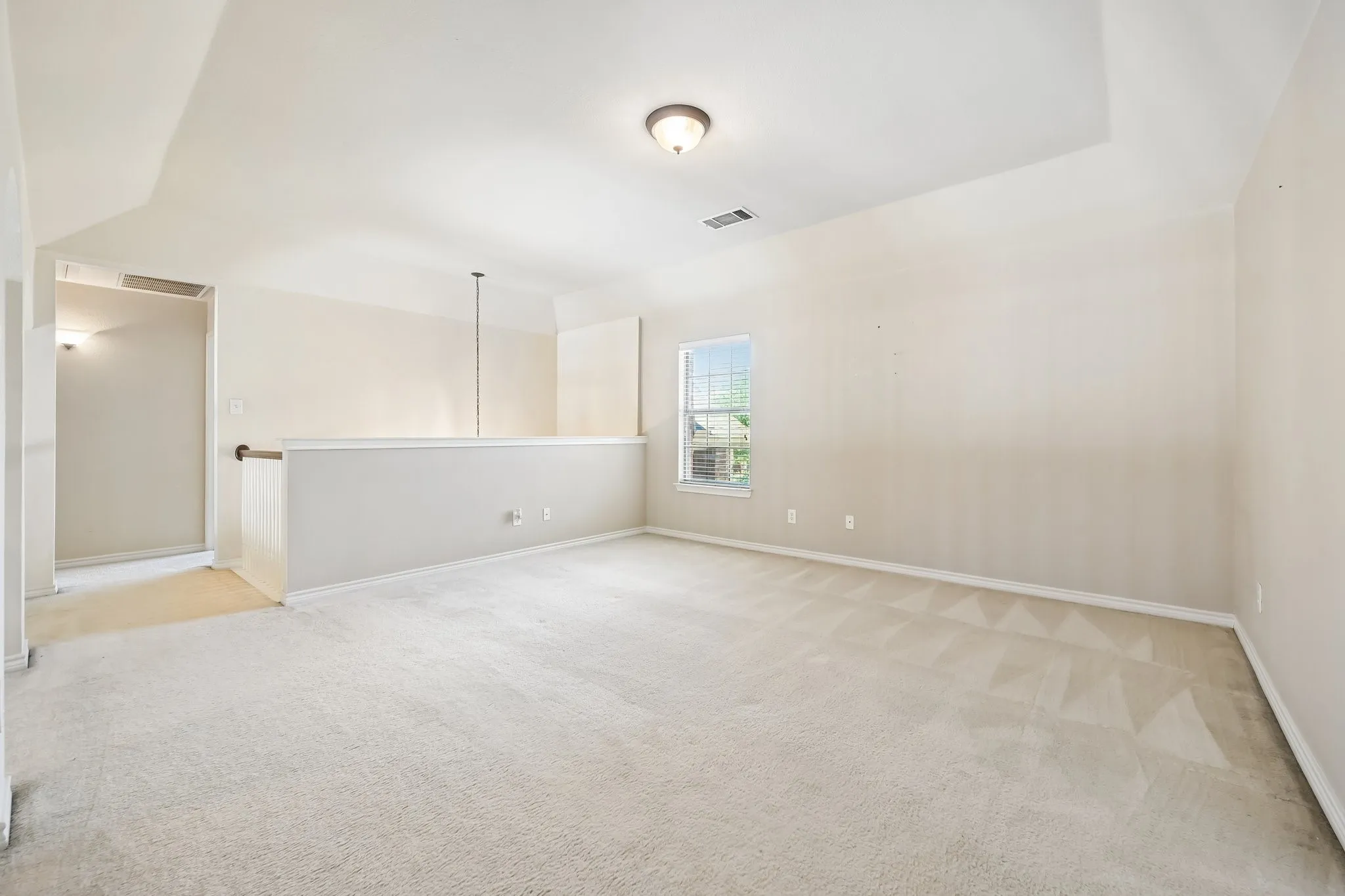 Carpeted upper level room featuring a tray ceiling, recessed lighting, and a single window