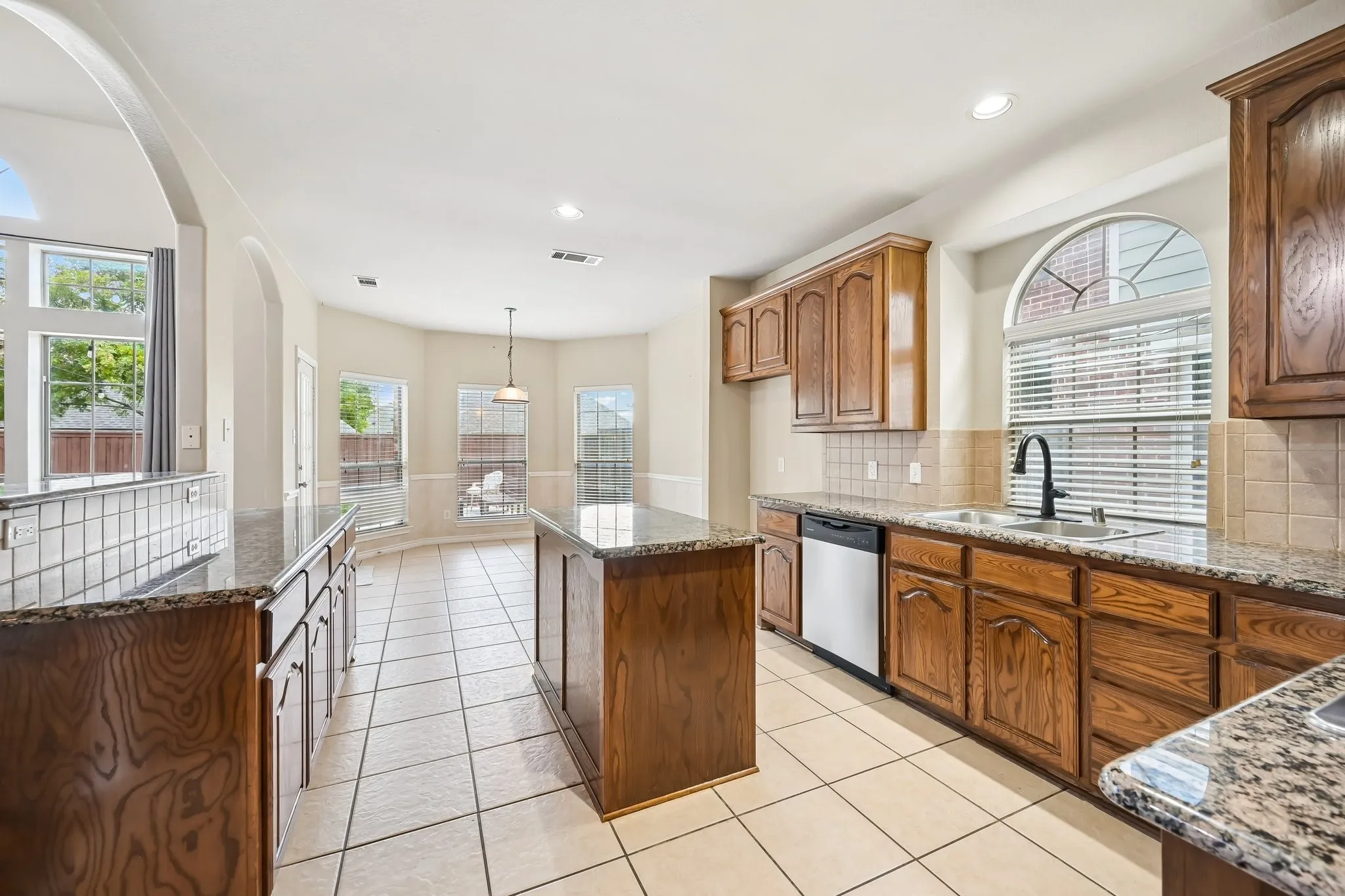 Kitchen featuring wood cabinetry, granite countertops, and a tile backsplash