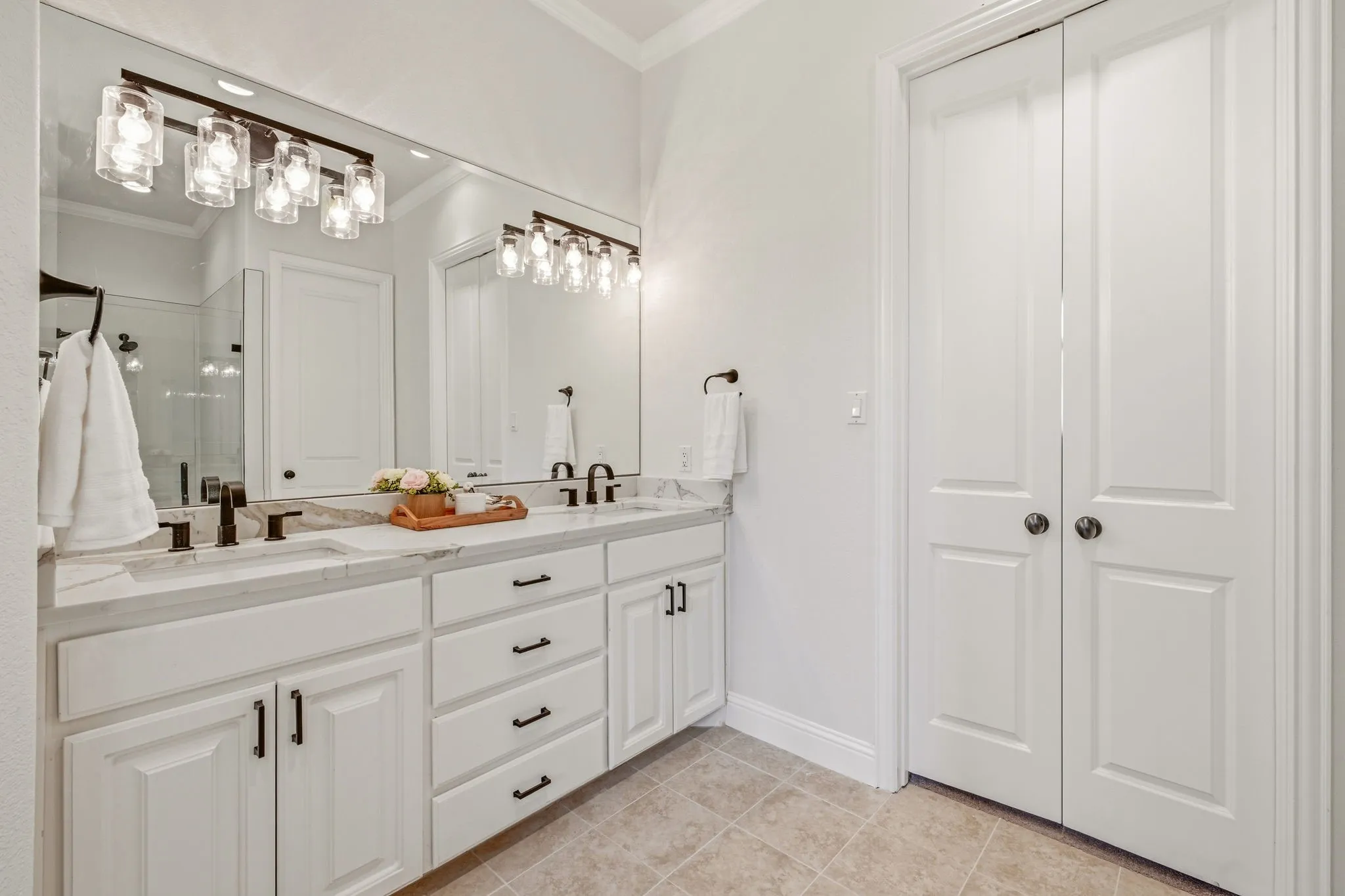 Primary Bath Double vanity featuring white cabinetry with dark hardware, undermount sinks, and a light-toned countertop