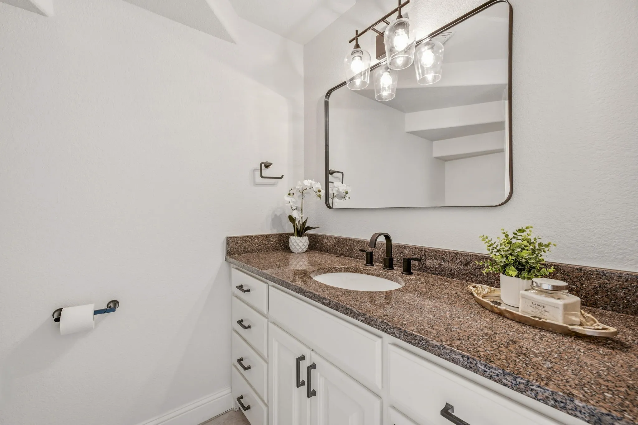 Half Bath White vanity with multiple drawers and cabinets, topped with a speckled​​‌​​​​‌​​‌‌​‌‌​​​‌‌​‌​‌​‌​​​‌​​ countertop