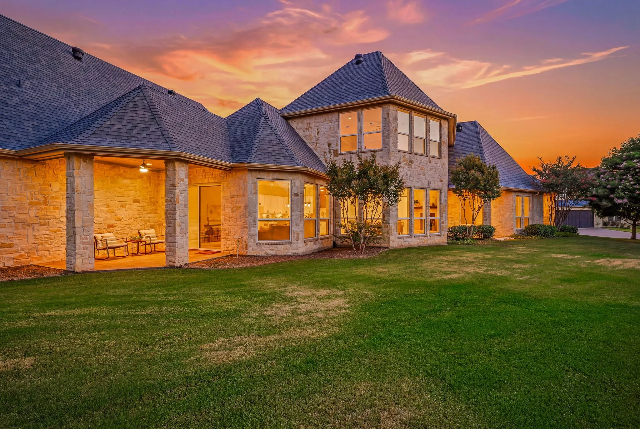 Stone exterior featuring multiple gables and a covered patio