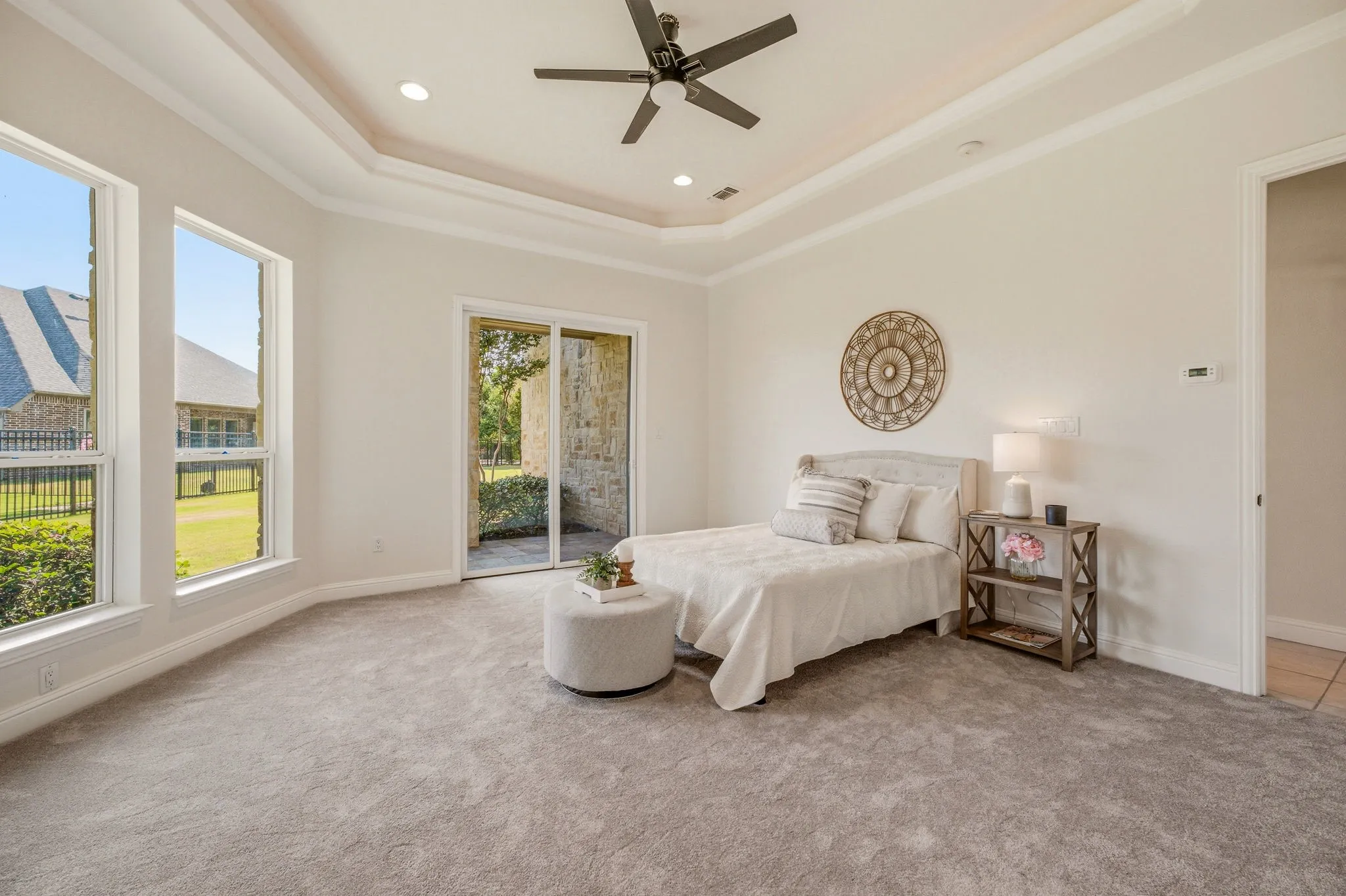 Expansive room featuring tray ceiling, recessed lighting, and a ceiling fan