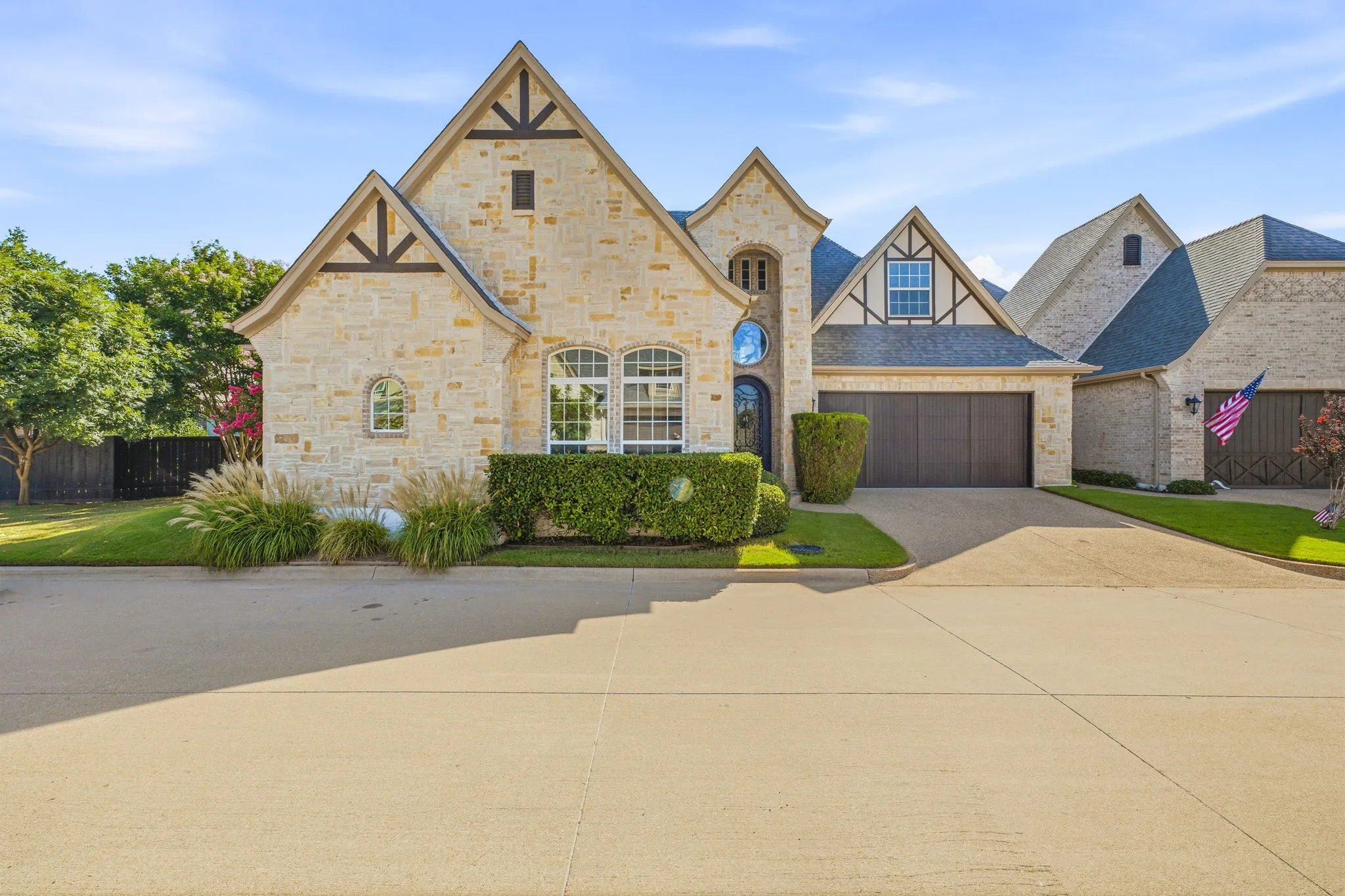 Stone exterior residence featuring multiple gables and a dark composition shingle roof