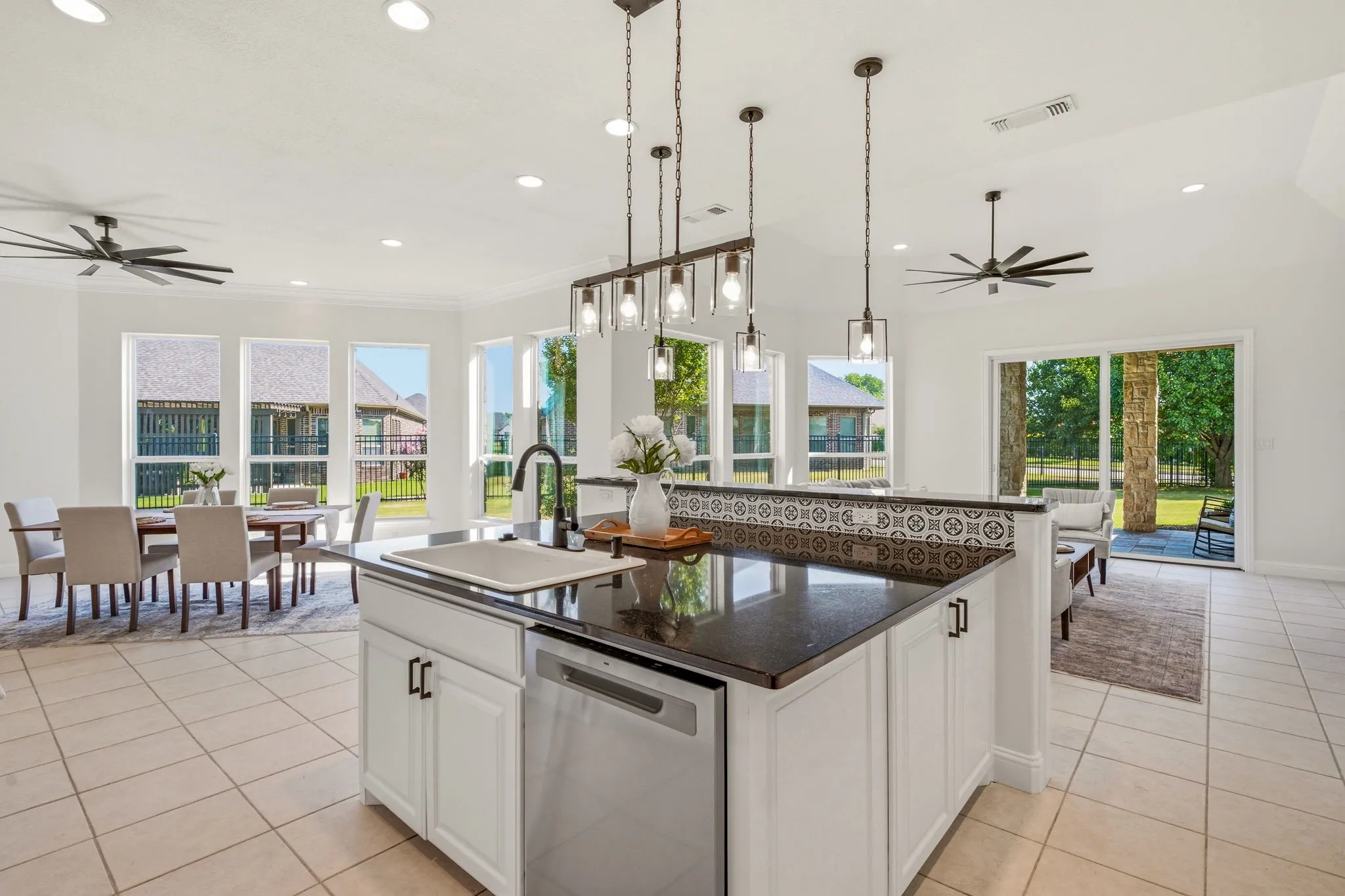Kitchen island featuring a dark countertop, undermount sink, and stainless steel dishwasher