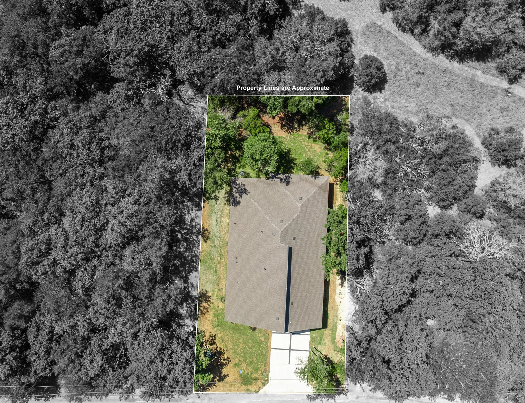 Aerial overview showcasing the property with a dark shingle roof and a concrete driveway