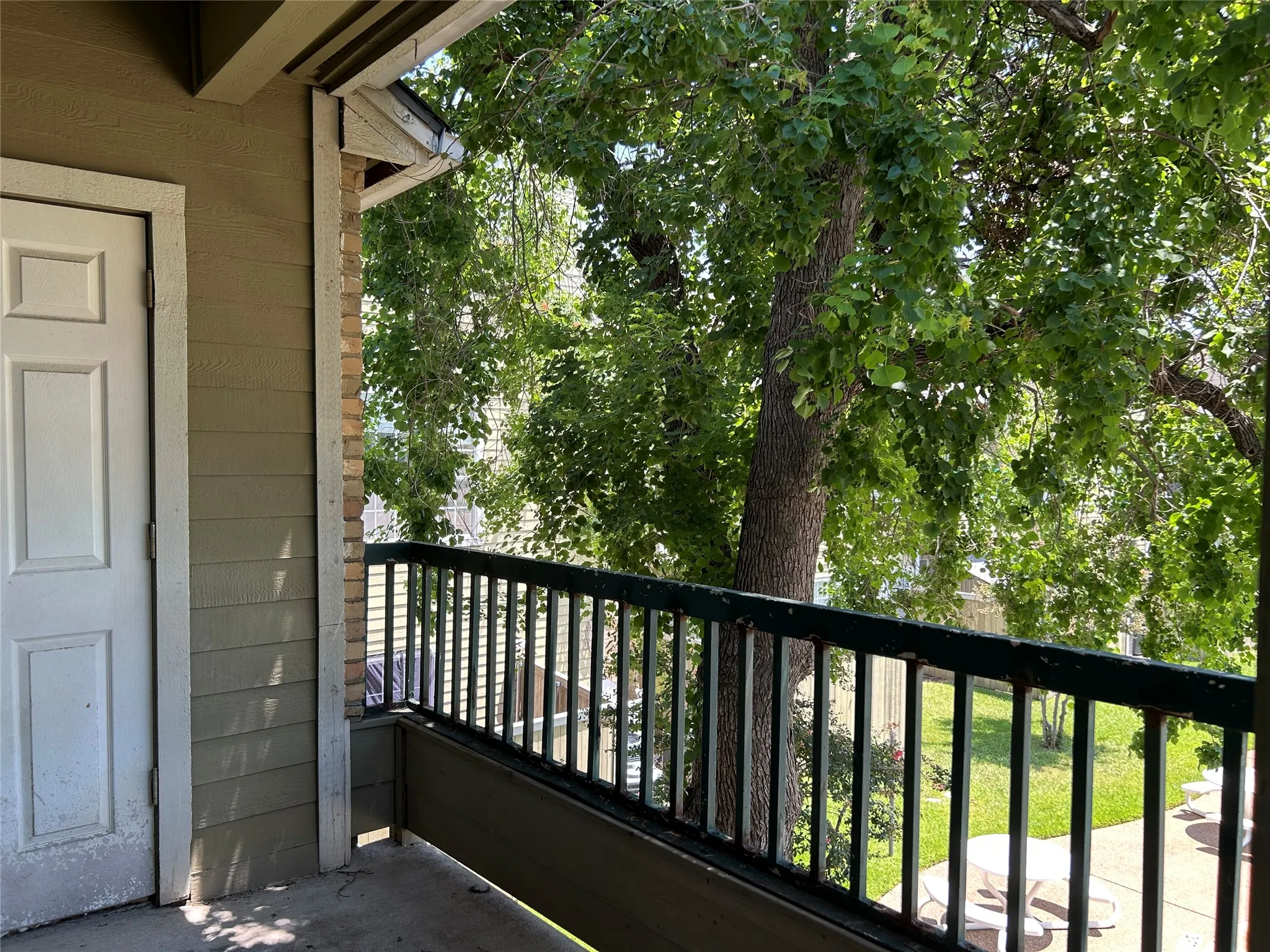 Private balcony with concrete flooring and dark-finish metal railing