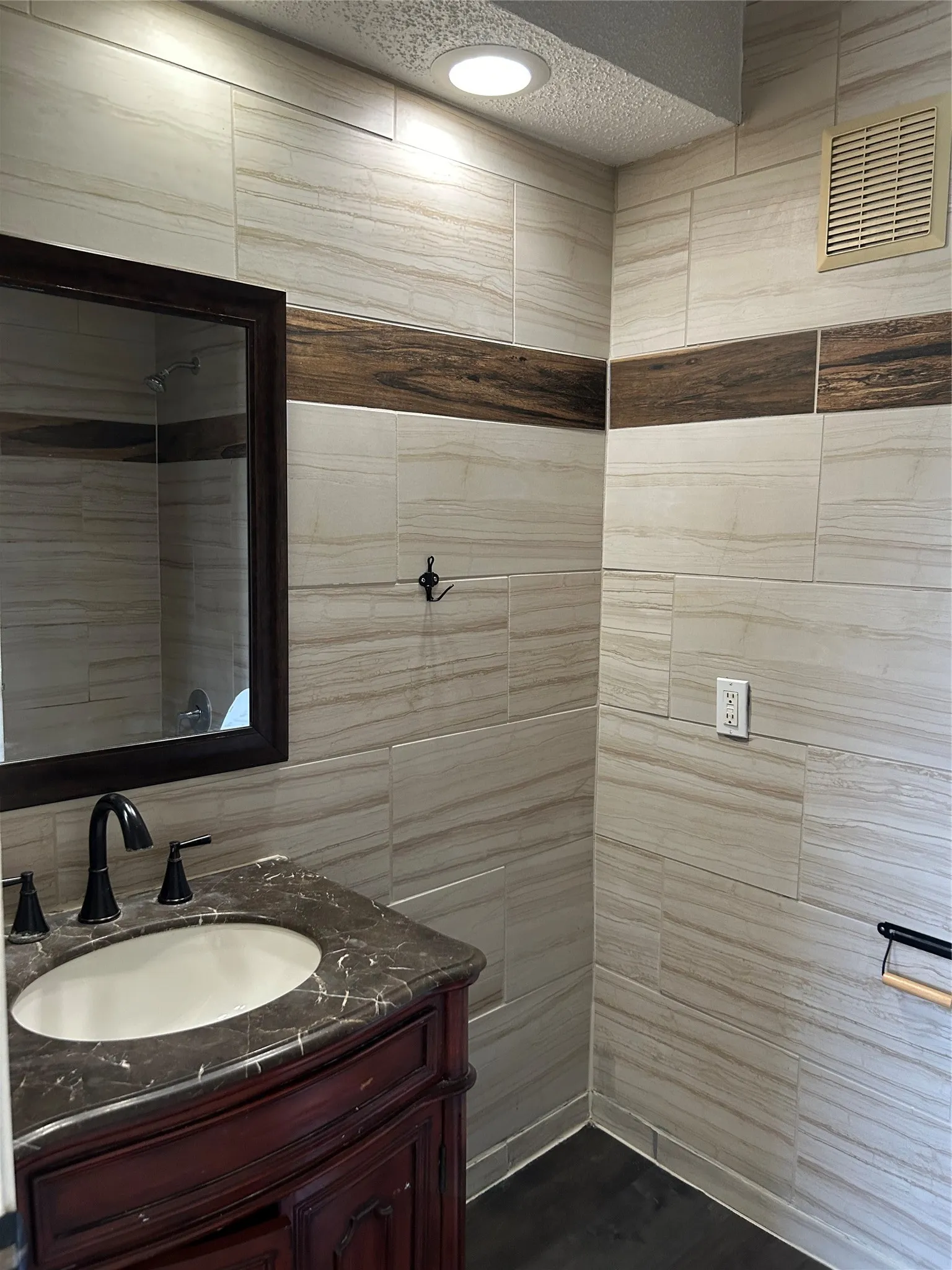 Bathroom featuring a dark wood vanity with a stone countertop and an undermount sink top