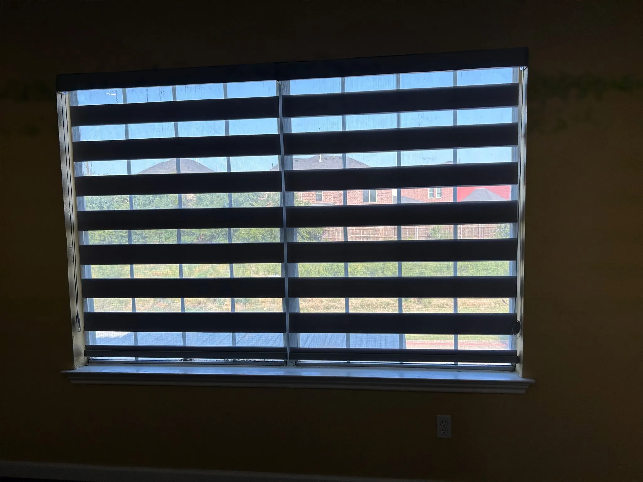 Window featuring layered shades and a white sill