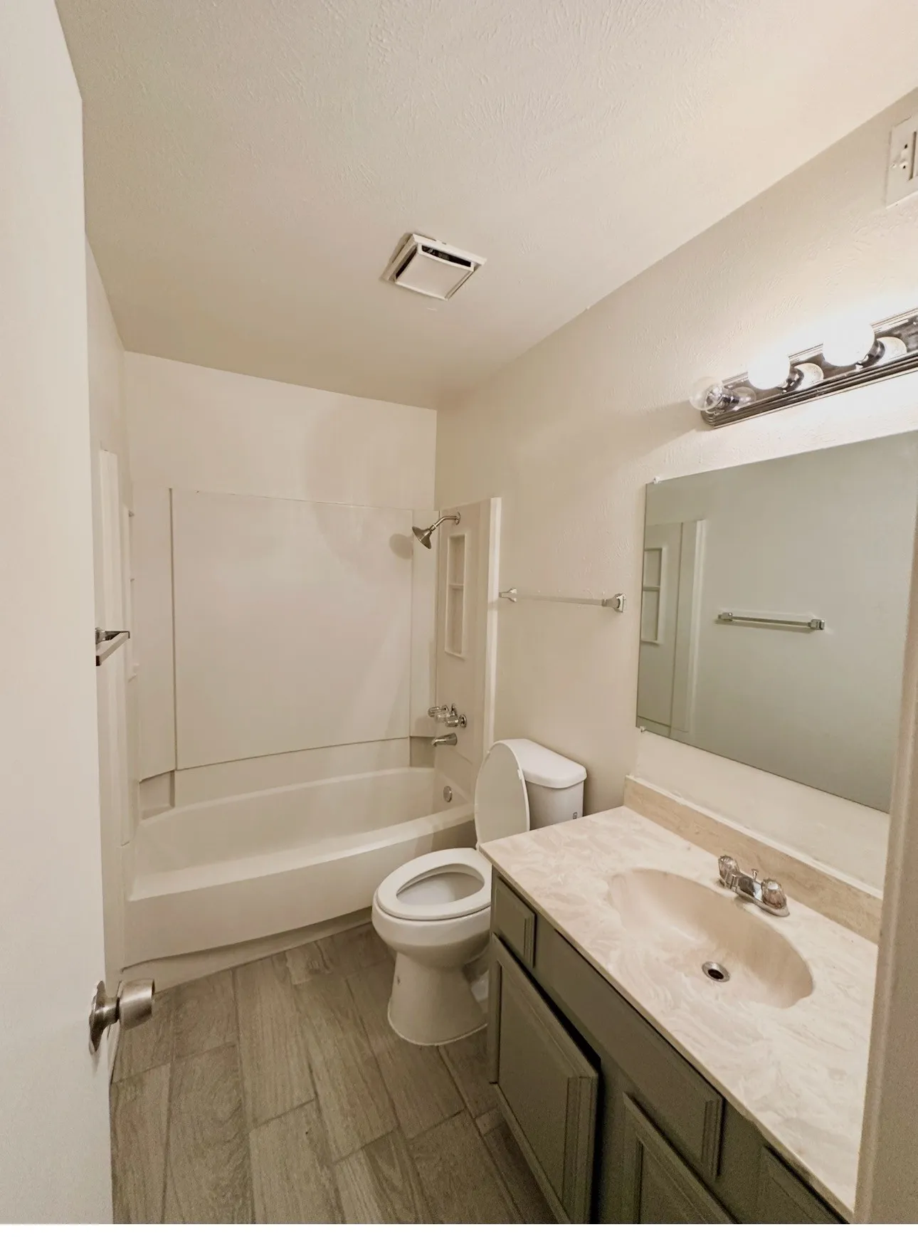 Full bathroom featuring a white tub/shower combination, tile-finish flooring, a vanity with an integrated sink, and an overhead light fixture