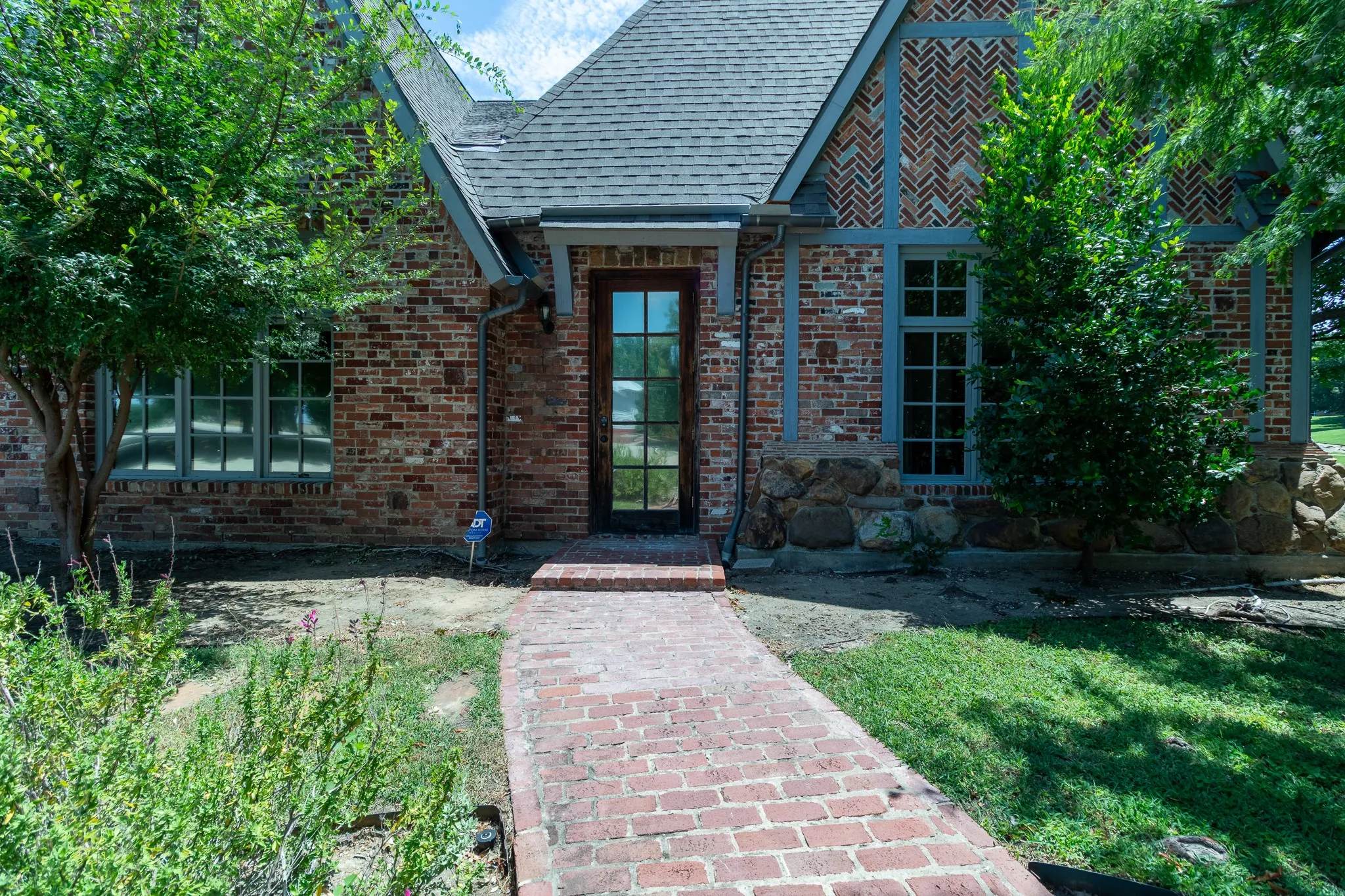 Brick and stone exterior featuring a gabled roofline and an arched entryway