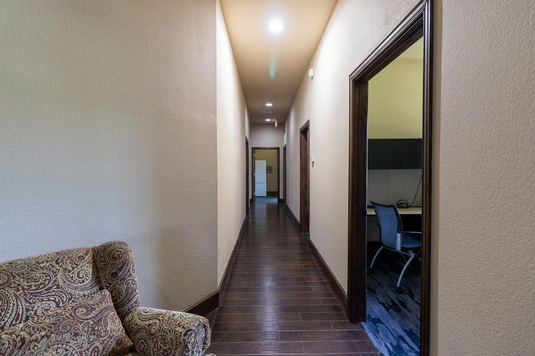 Hallway featuring wood-finish flooring, recessed lighting, and dark wood trim