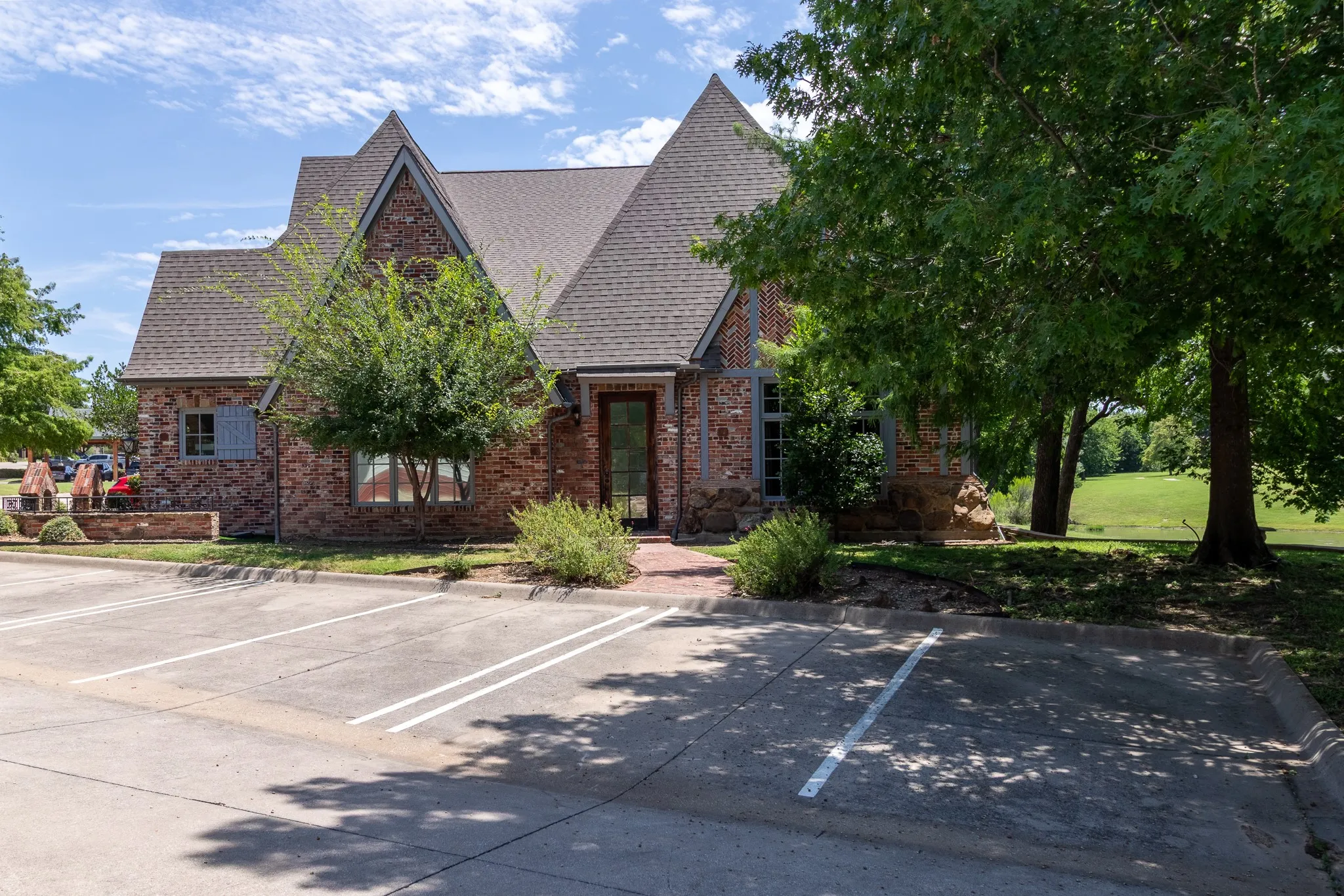 Brick and stone facade building with multiple gables and a shingle roof