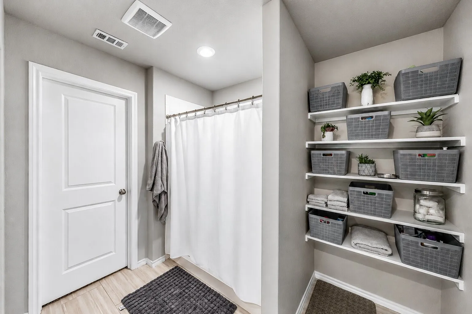 Bathroom featuring a shower with a white curtain, light wood-finish flooring, recessed lighting, and an expansive built-in shelving unit