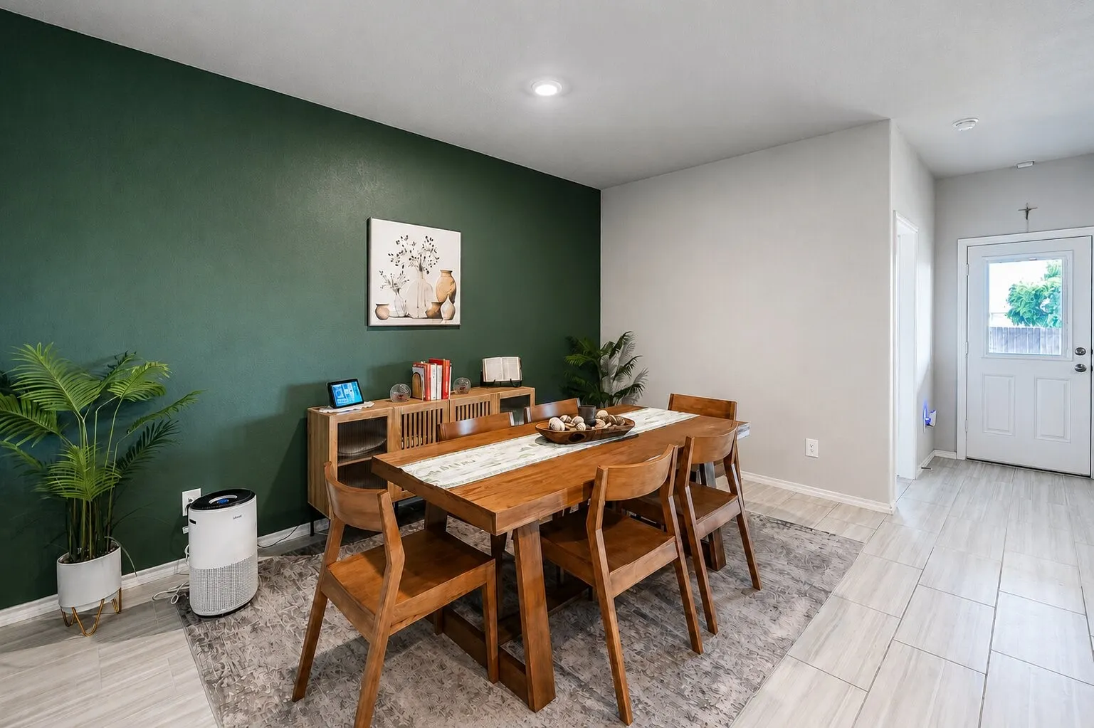 Dining area featuring a dark green accent wall, recessed lighting, and light-toned wood-finish flooring