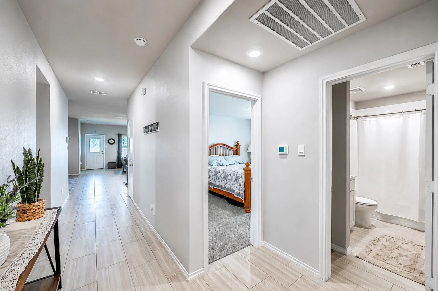 Hallway featuring wood-finish tile flooring, recessed lighting, and a white interior door