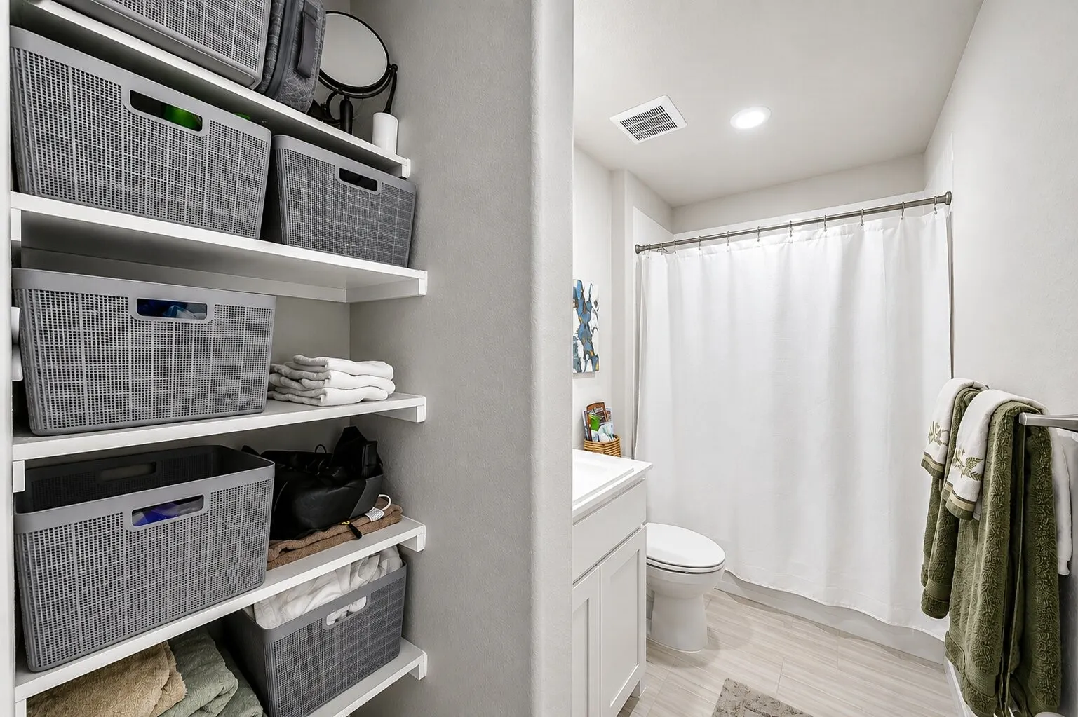 Full bathroom featuring a white vanity with integrated sink, toilet, and shower with curtain rod