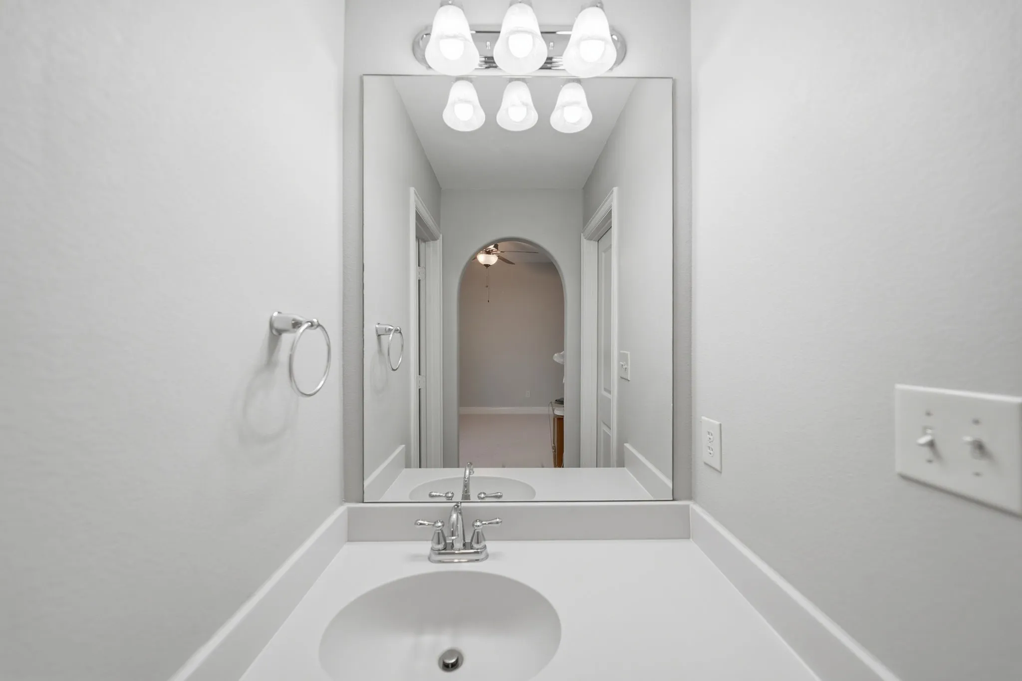 Bathroom vanity featuring a polished chrome faucet, an undermount sink, and a solid surface countertop