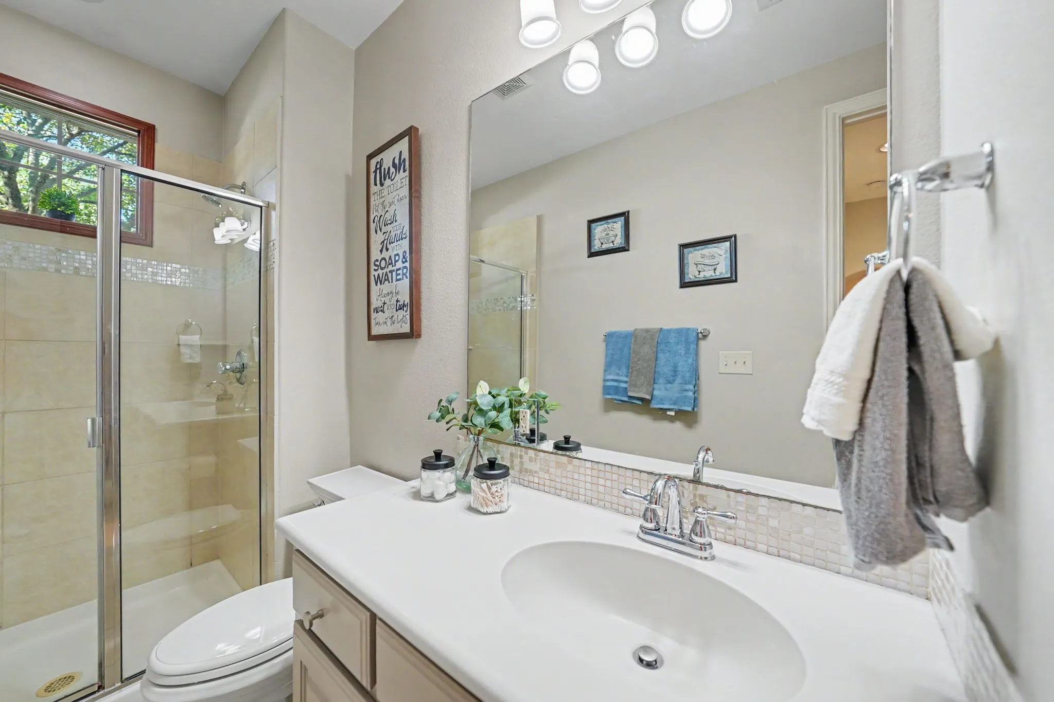 Glass-enclosed shower with tile surround and built-in bench